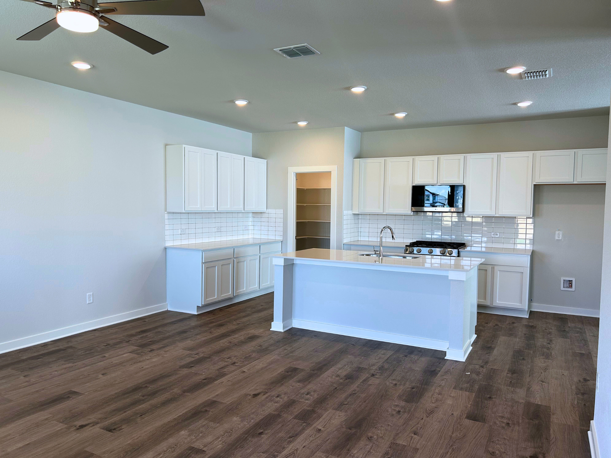 A kitchen with white cabinets.