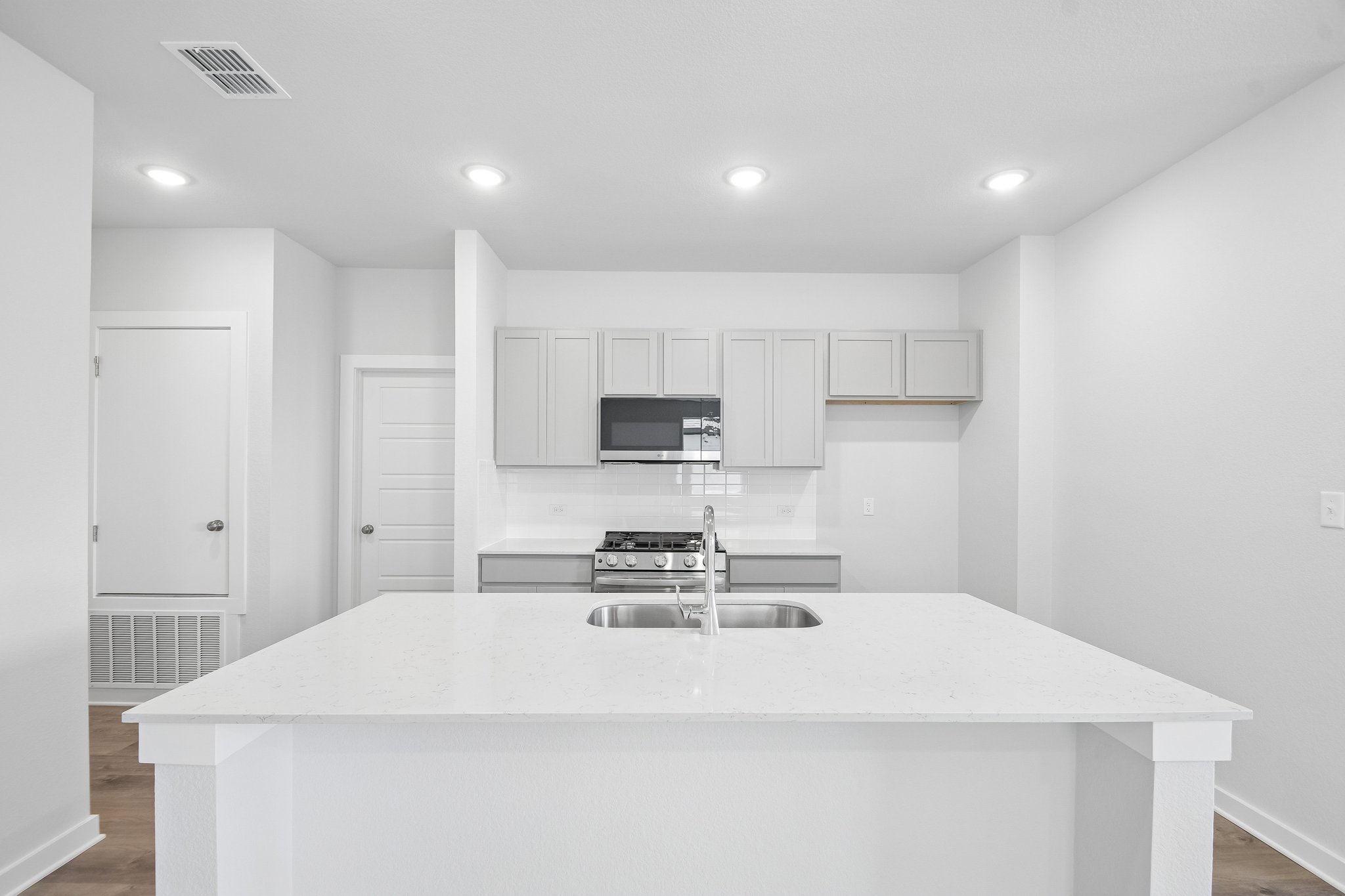 A kitchen with white cabinets.