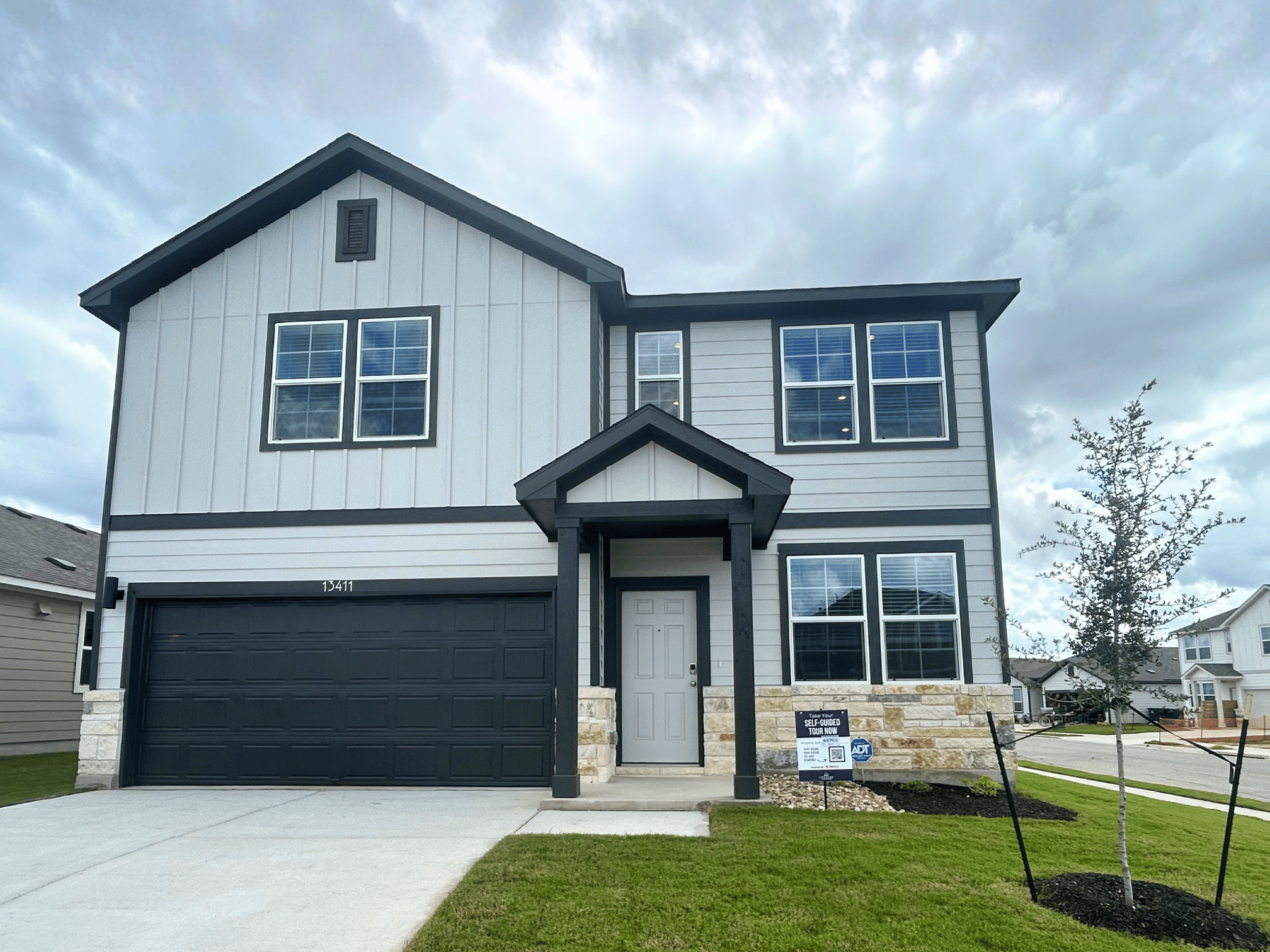 A grey house with a black garage.