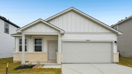 A white garage with a garage with American Gothic House in the background.