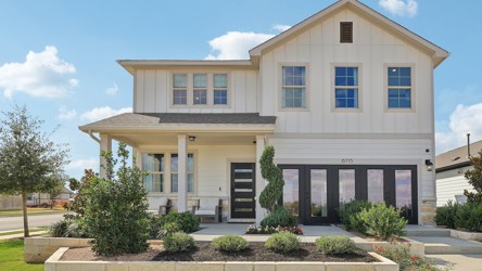 A white house with a green lawn.