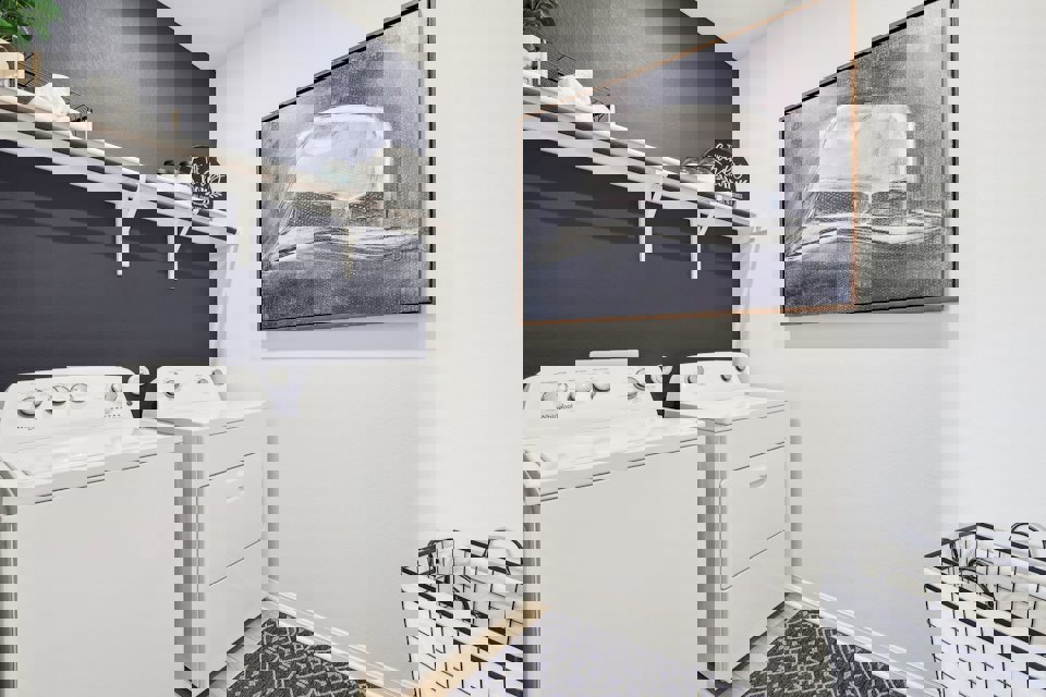 A laundry room with a shelf and a radiator.