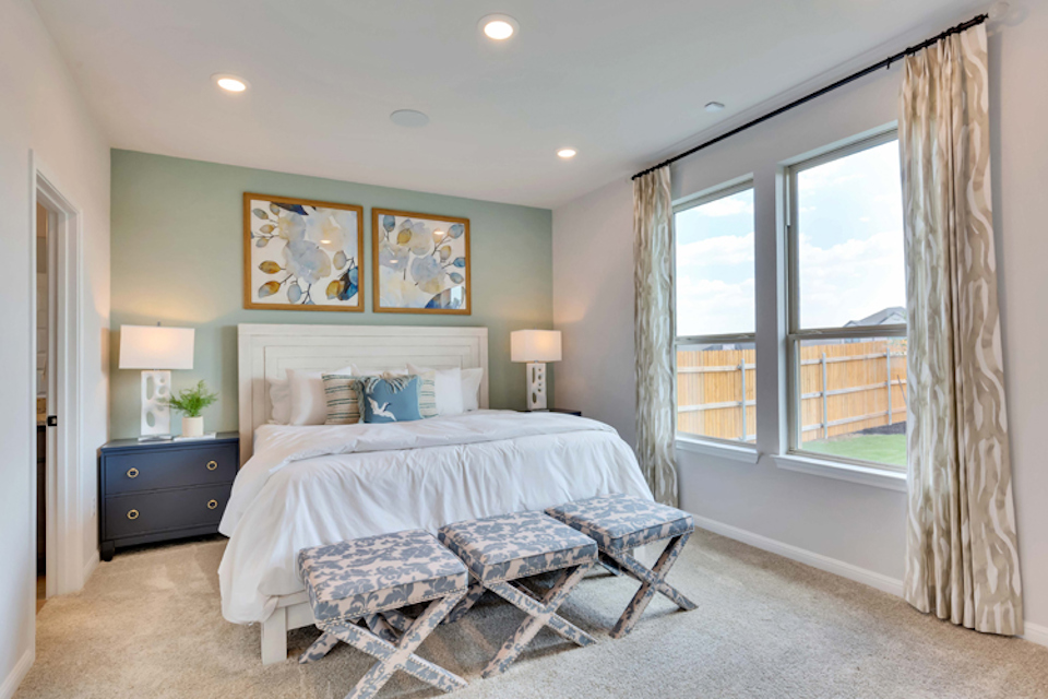 A bedroom with a bed and a bench.