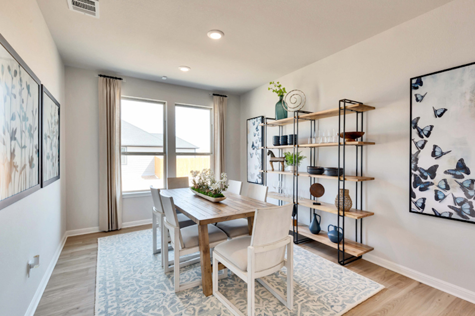 A dining room with a table and chairs.