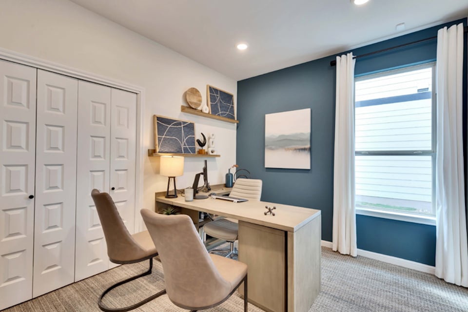 A room with a desk and chairs.