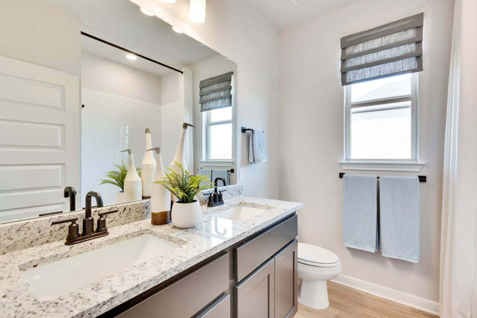 A bathroom with a sink toilet and towels.