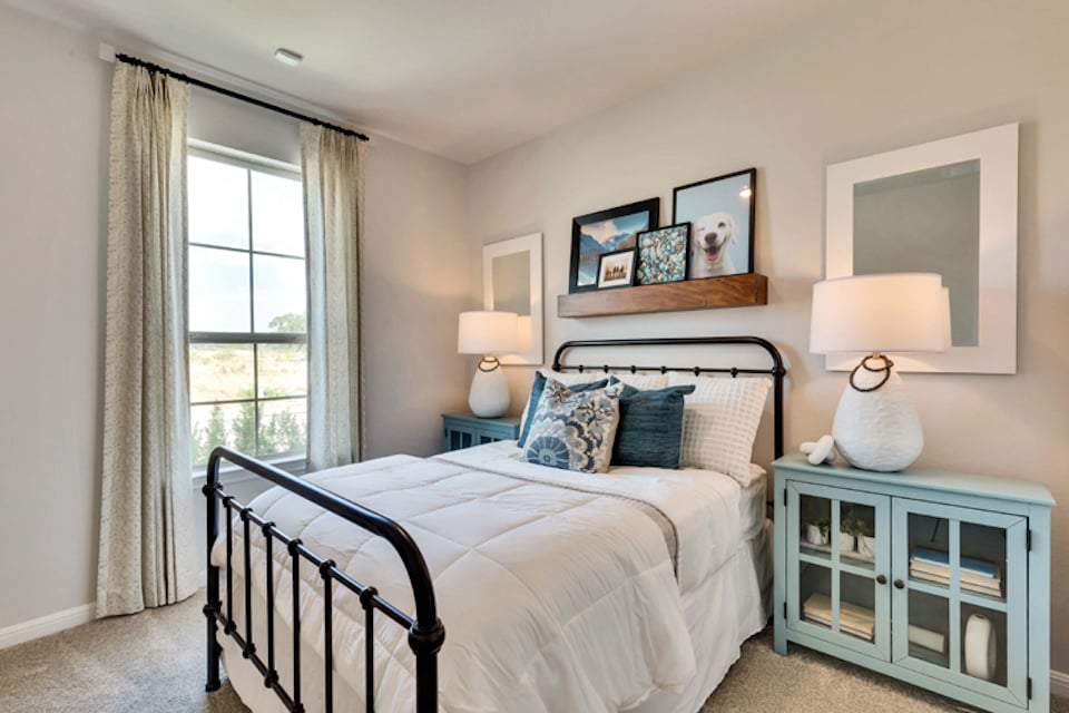 A bedroom with a bed and lamps.