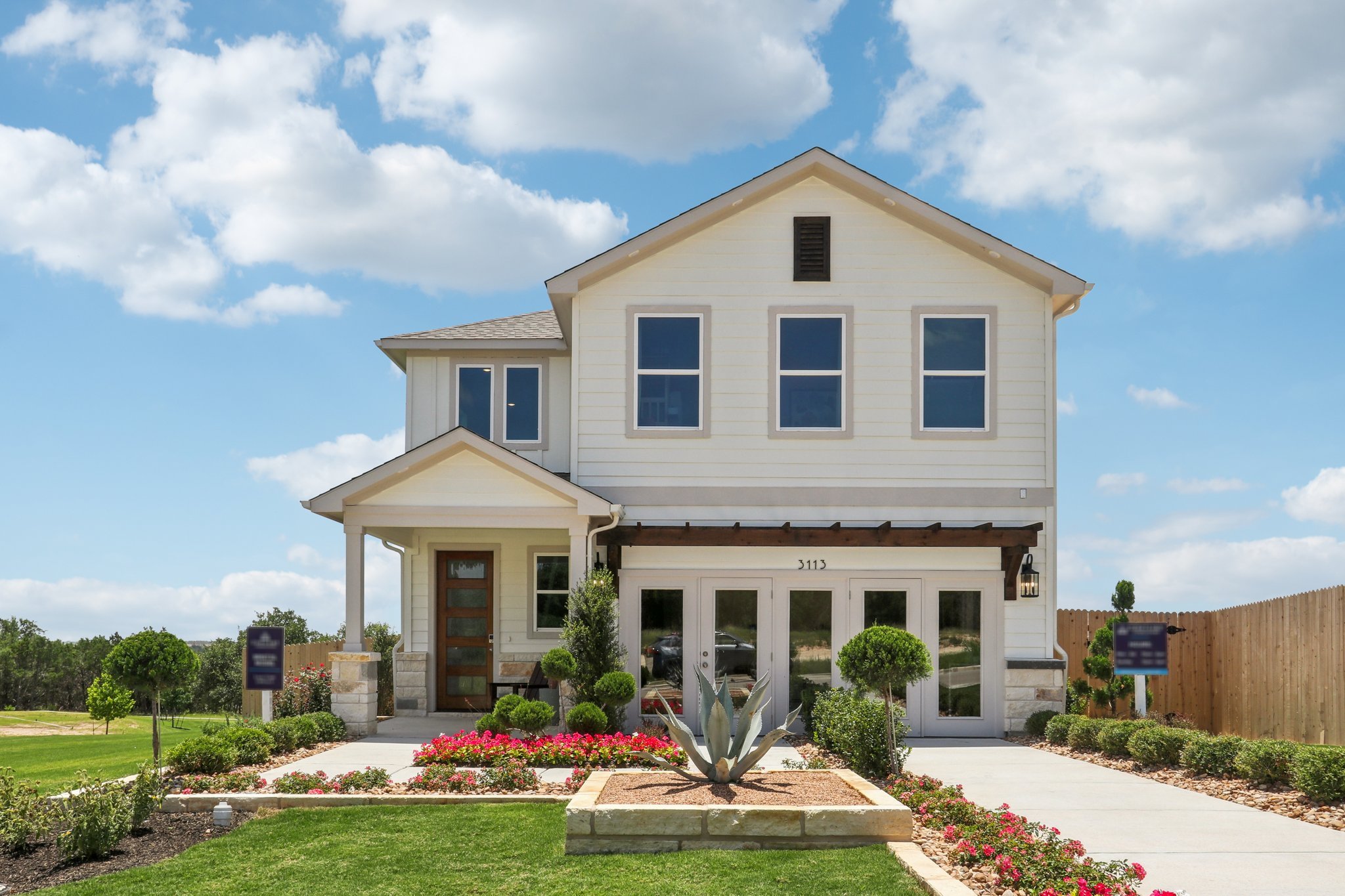 A white house with a fountain in front of it.
