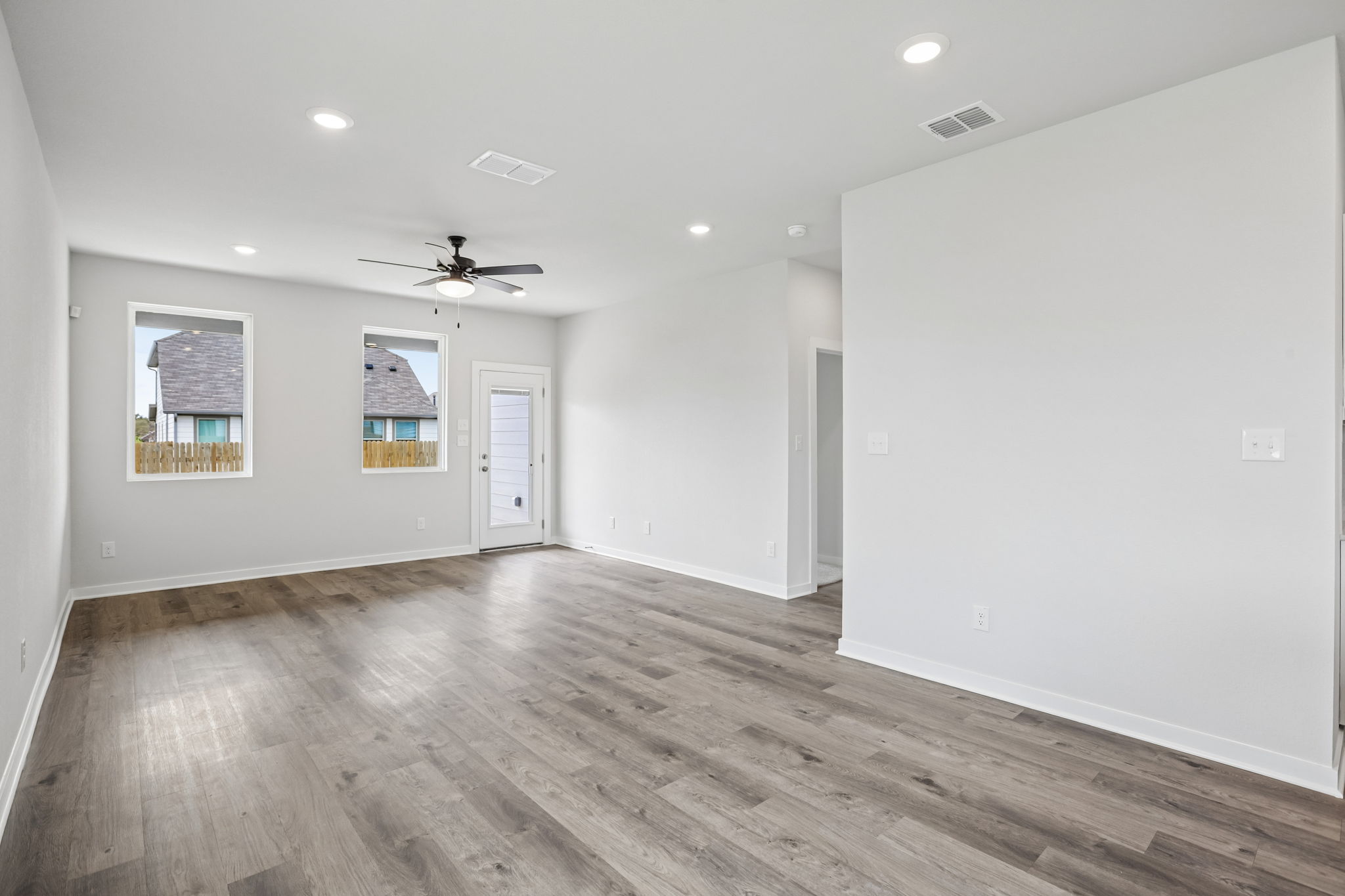 A room with a wood floor and a ceiling fan.