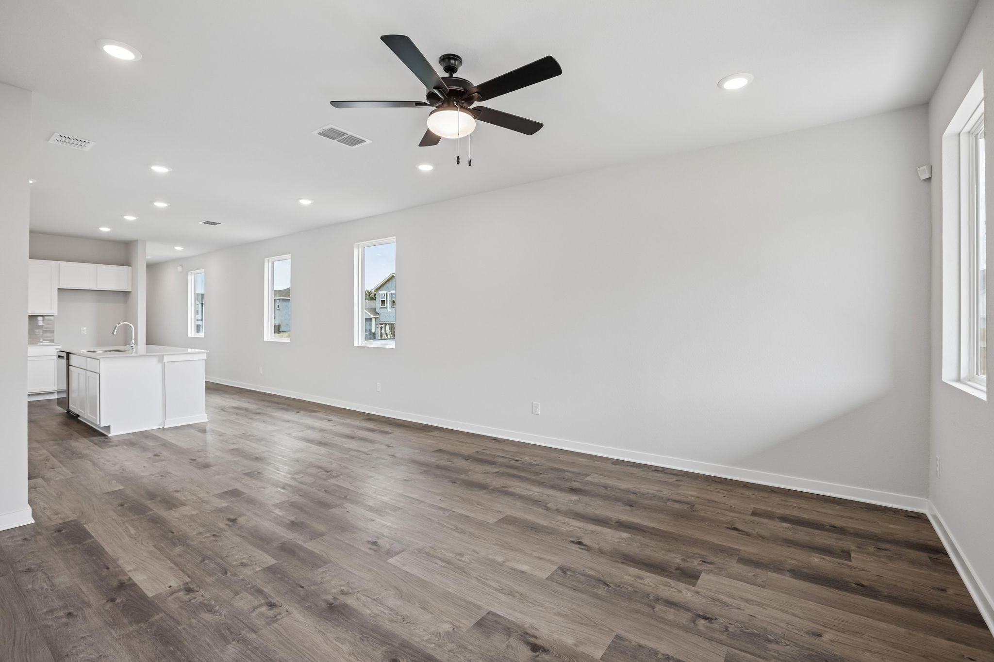 A room with a wood floor and a ceiling fan.