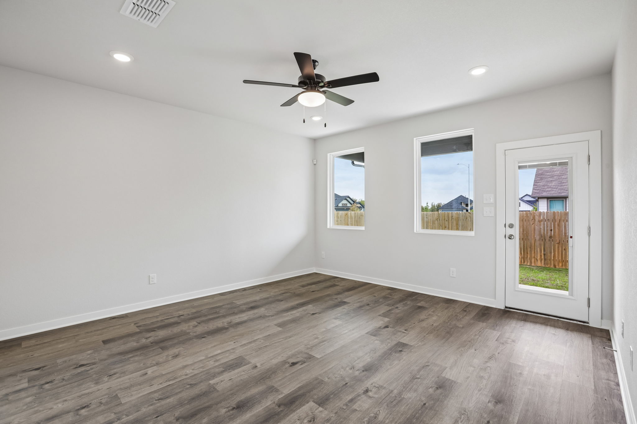 A room with a wood floor and a ceiling fan.