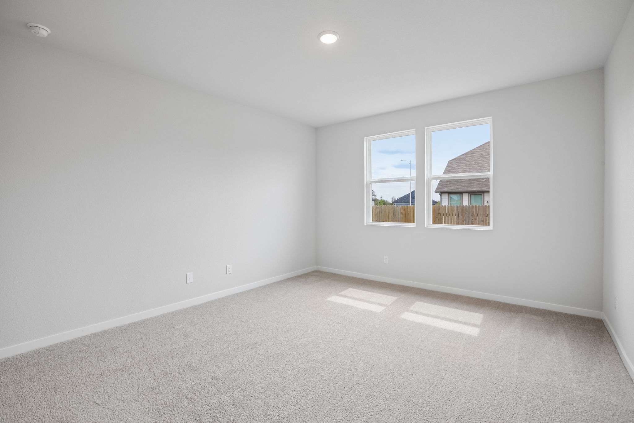 A room with a window and a white wall.