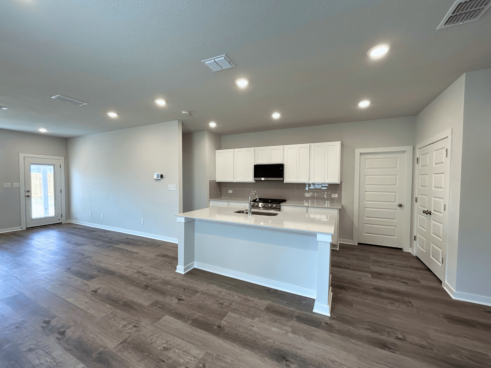 A kitchen with white cabinets.