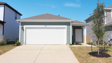 A one-story house with garages and a tree.