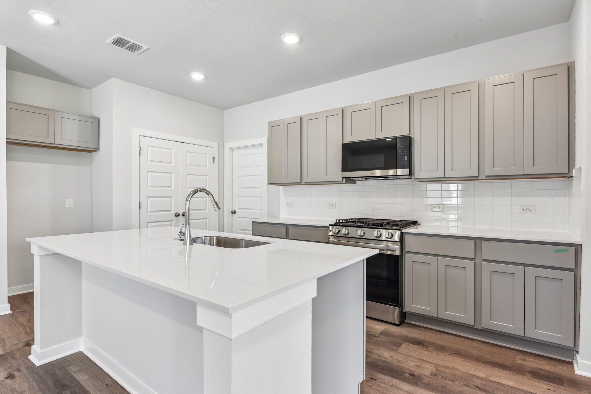 A kitchen with white cabinets.