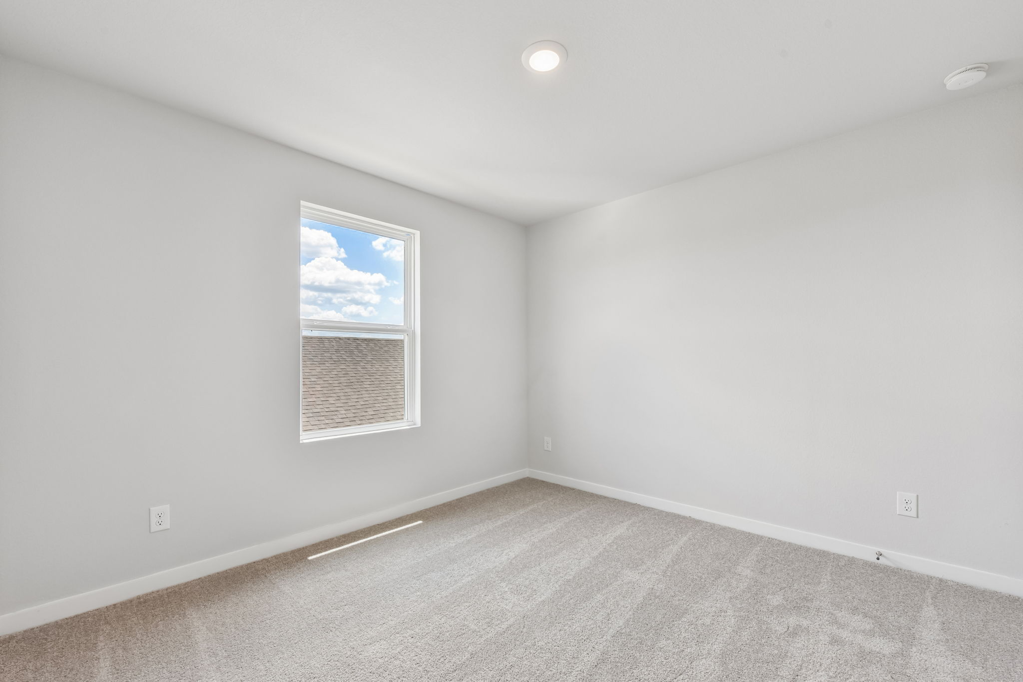 A room with a window and a rug.