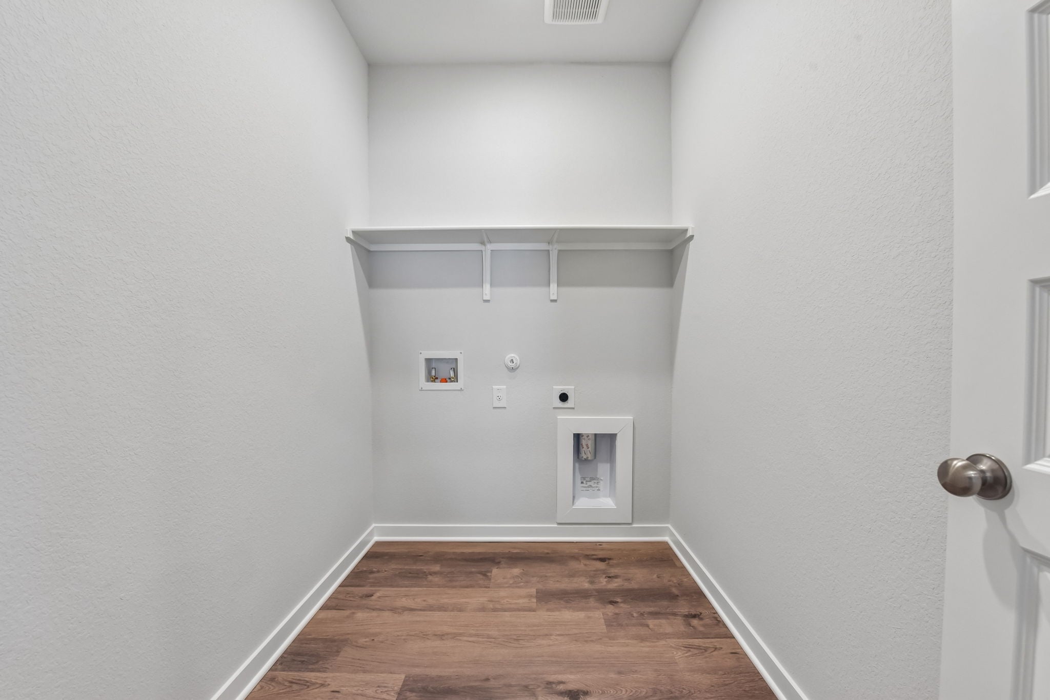 A room with a wood floor and white walls.