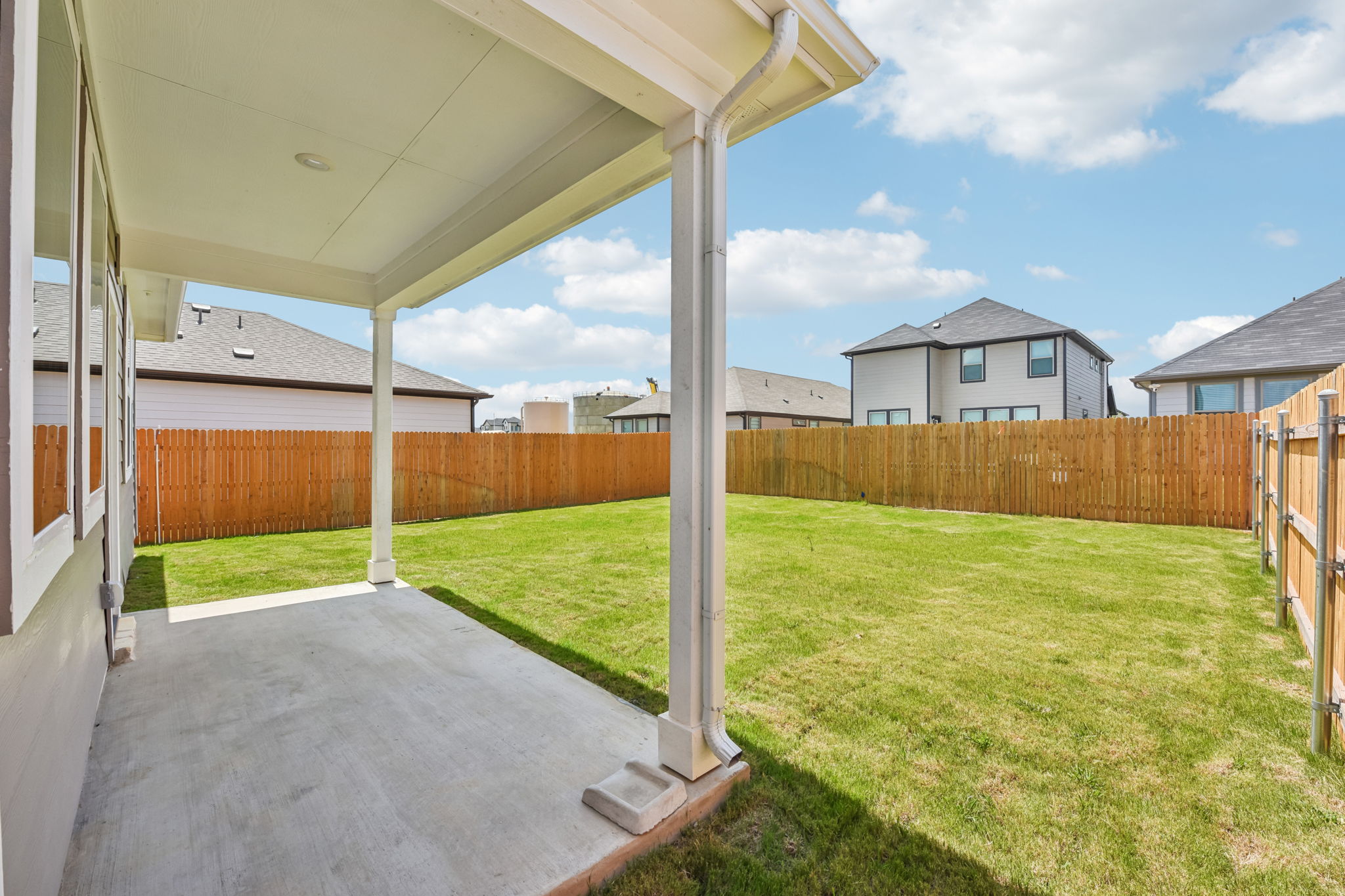 A backyard with a covered patio.