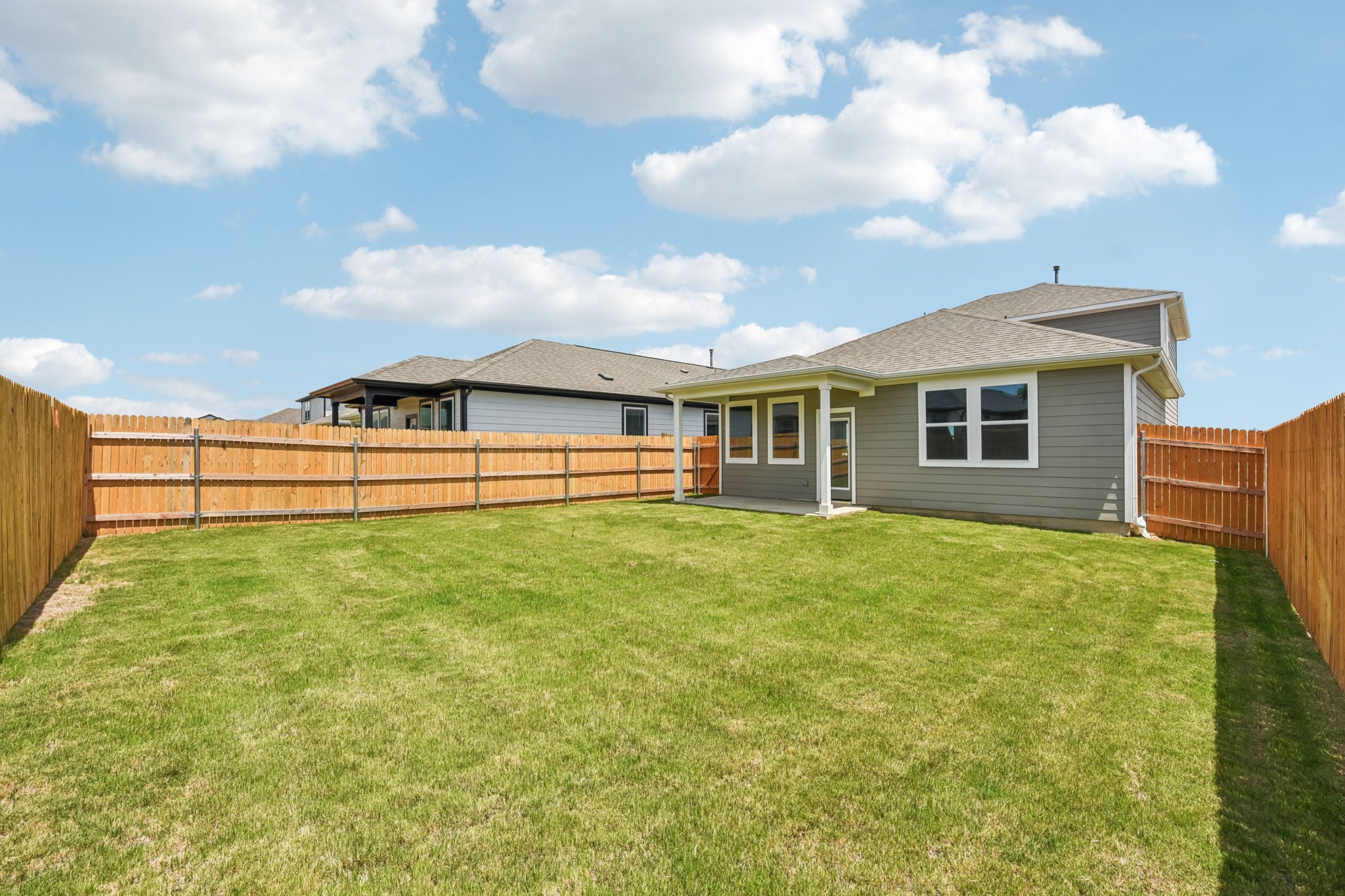 A house with a fence and grass.