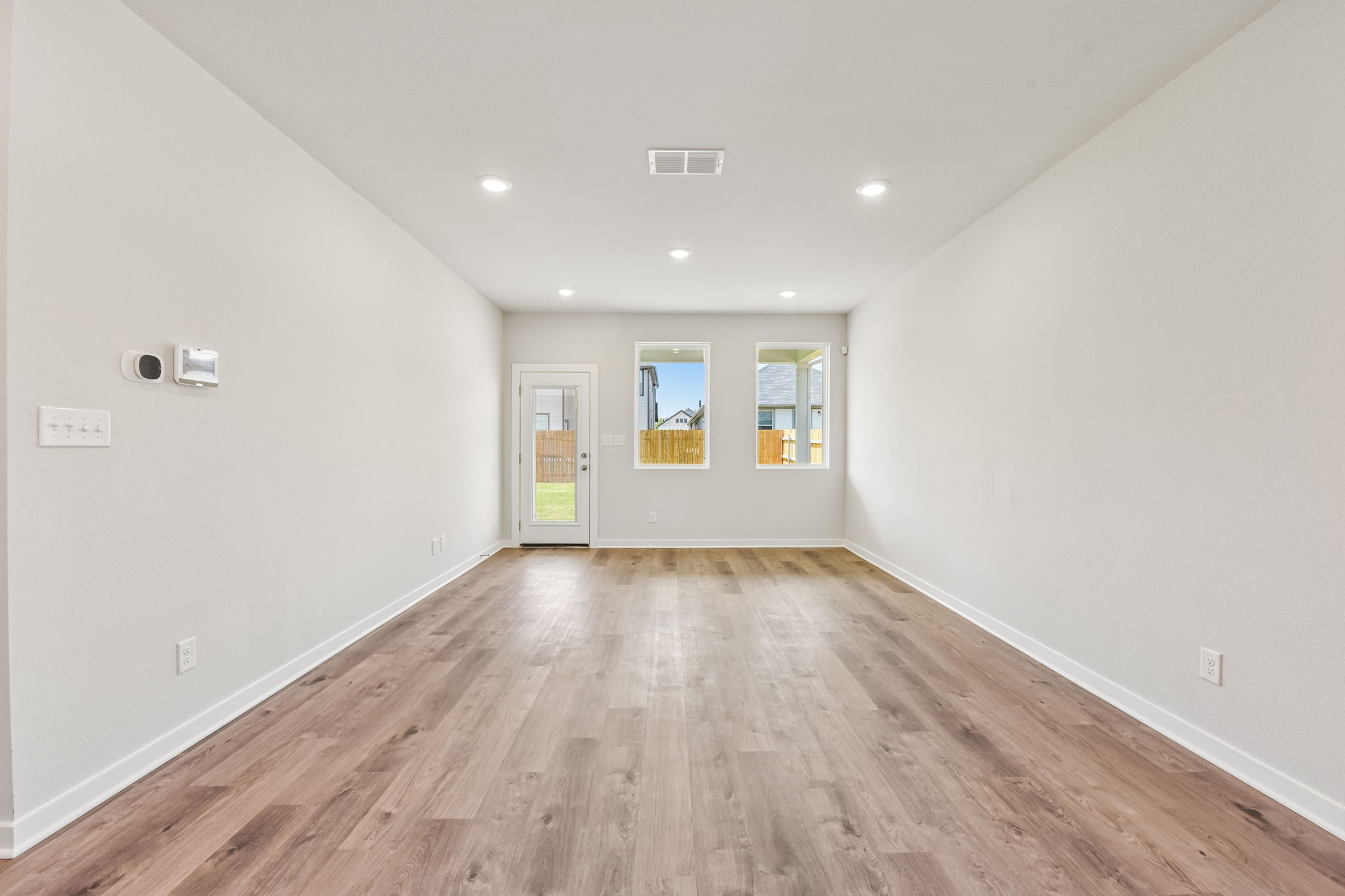 A room with white walls and a wood floor.