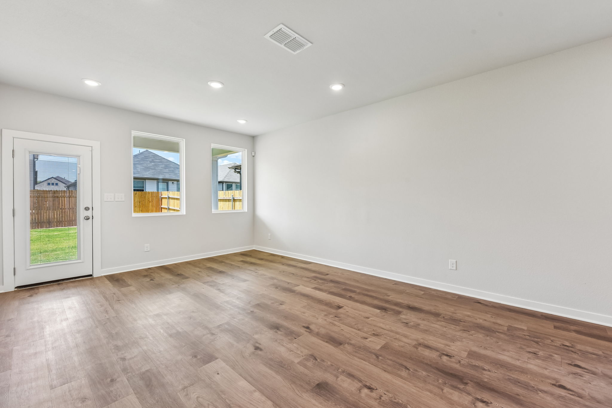 A room with a wood floor and windows.