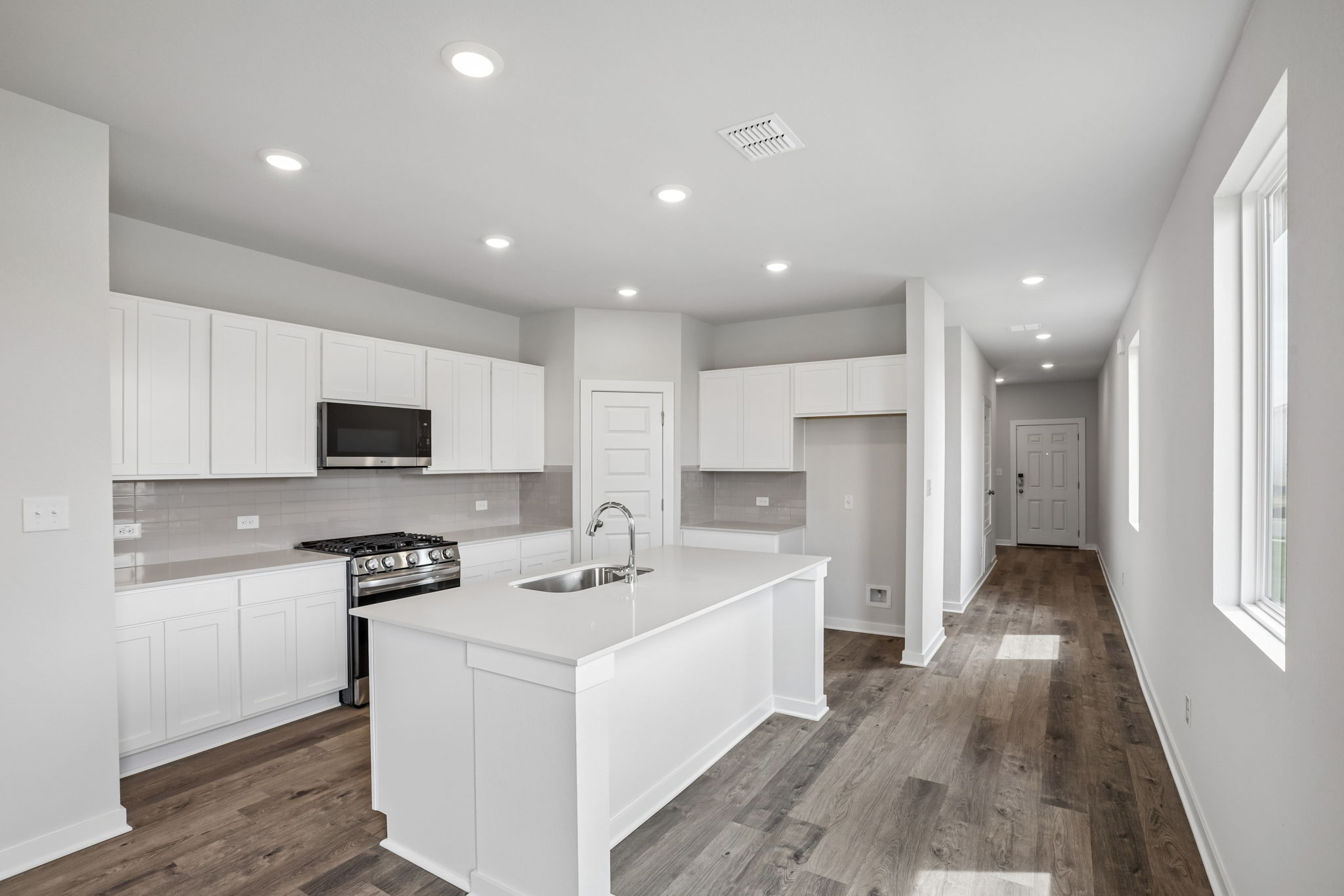 A kitchen with white cabinets.