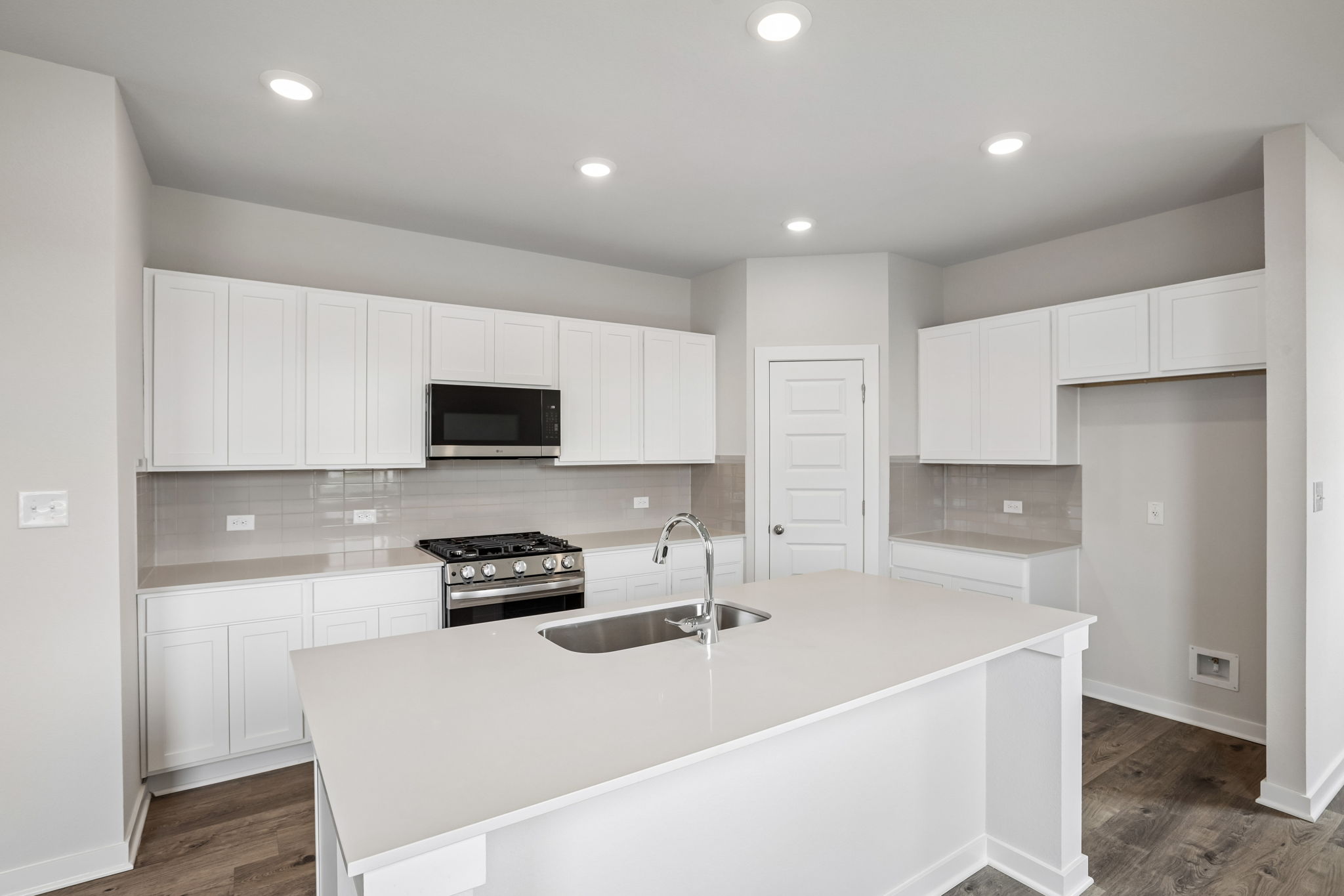 A kitchen with white cabinets.