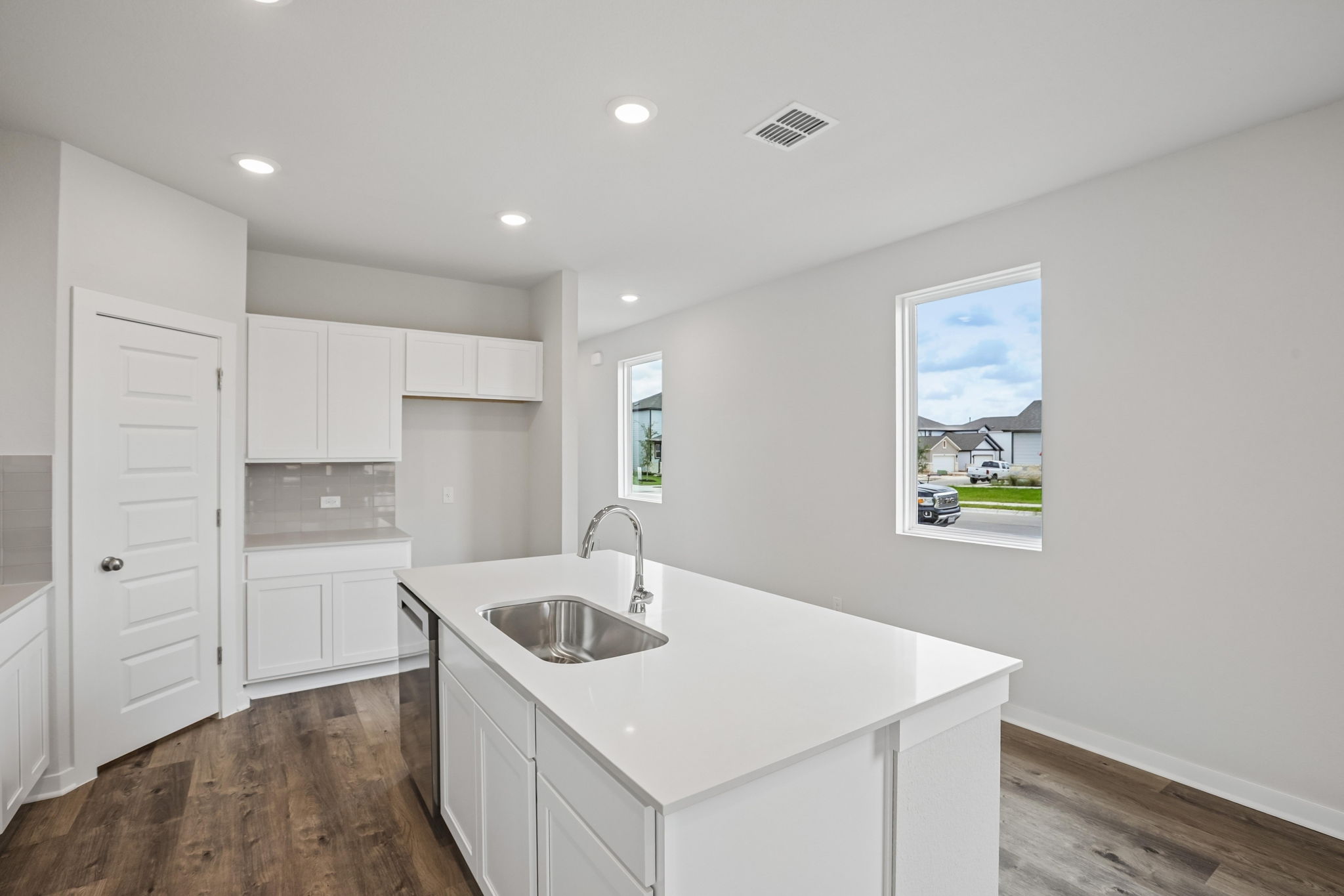 A kitchen with white cabinets.