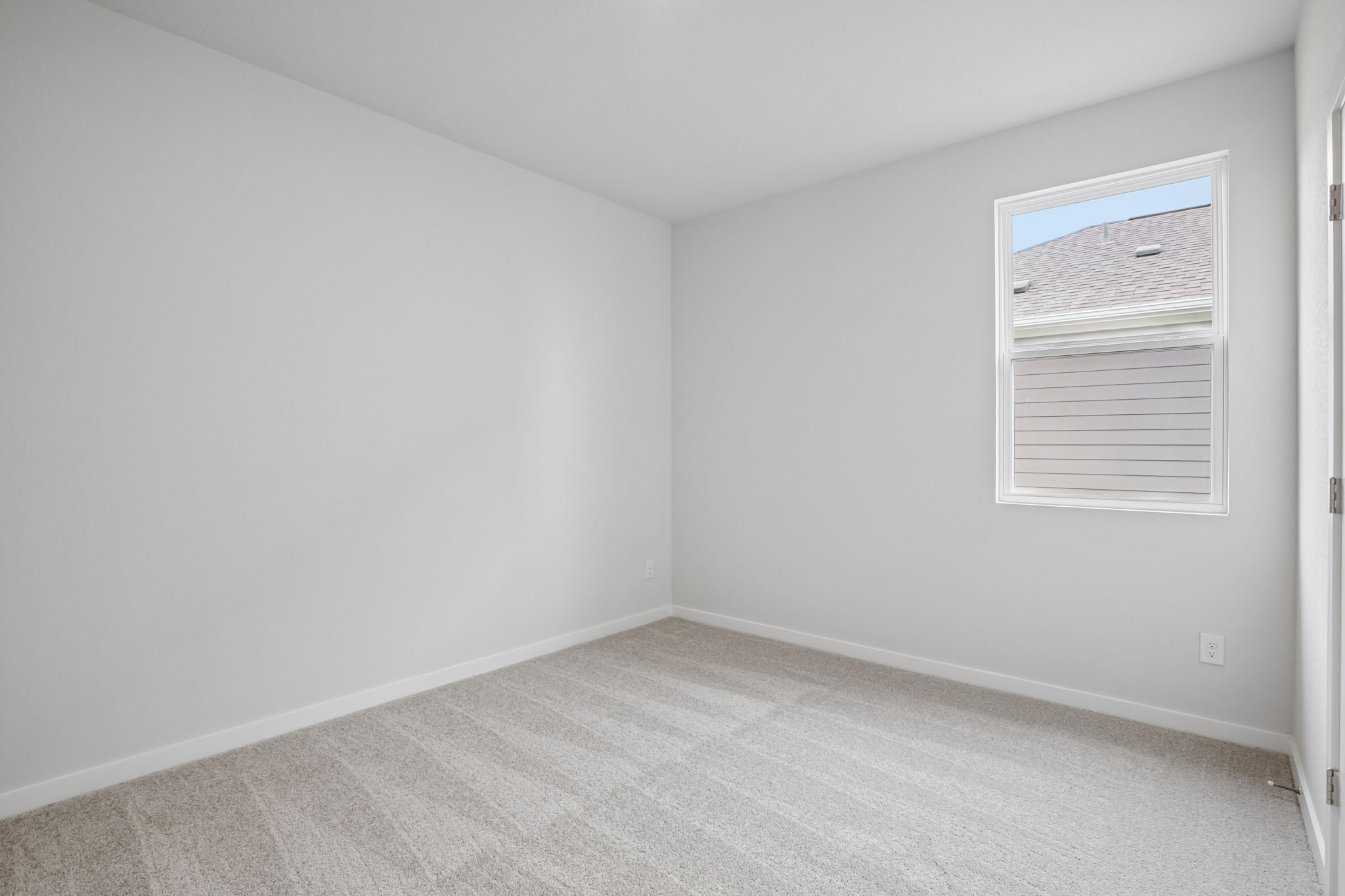 A room with a white wall and a window.