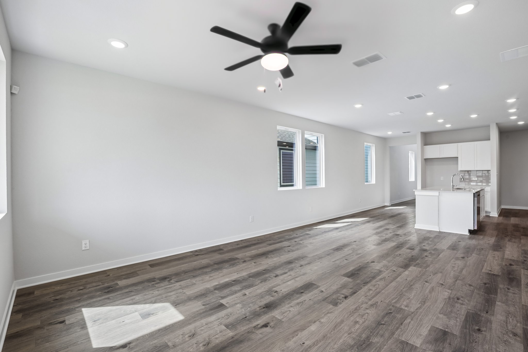 A room with a wood floor and a ceiling fan.