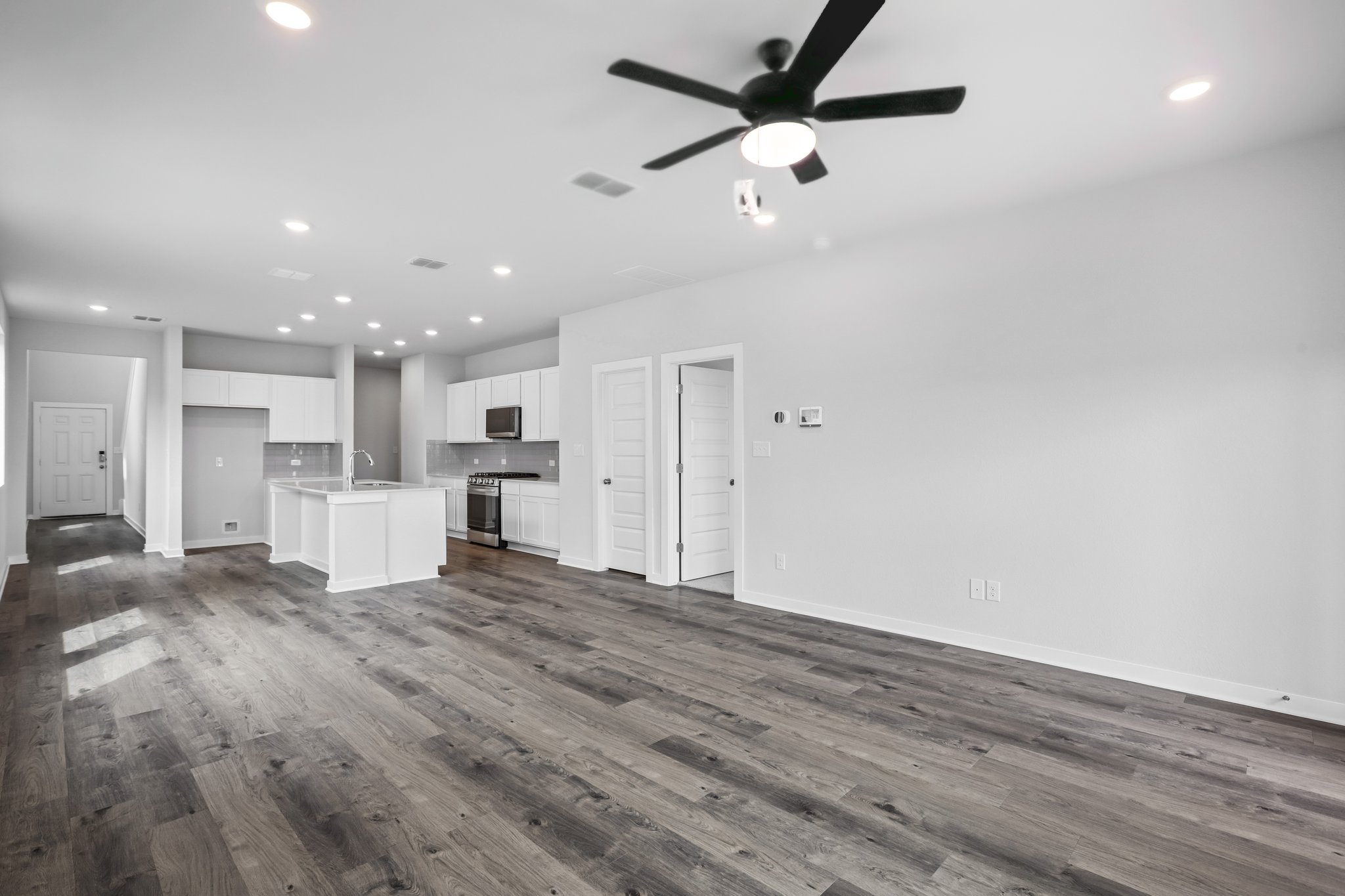 A room with white cabinets and a ceiling fan.