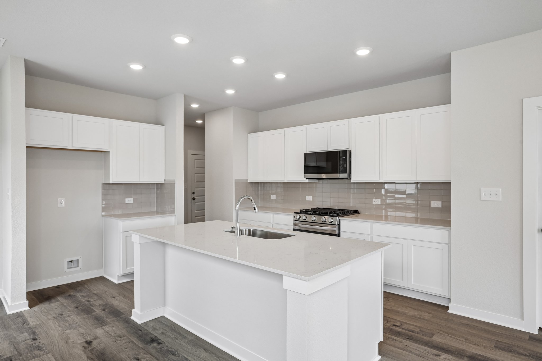 A kitchen with white cabinets.