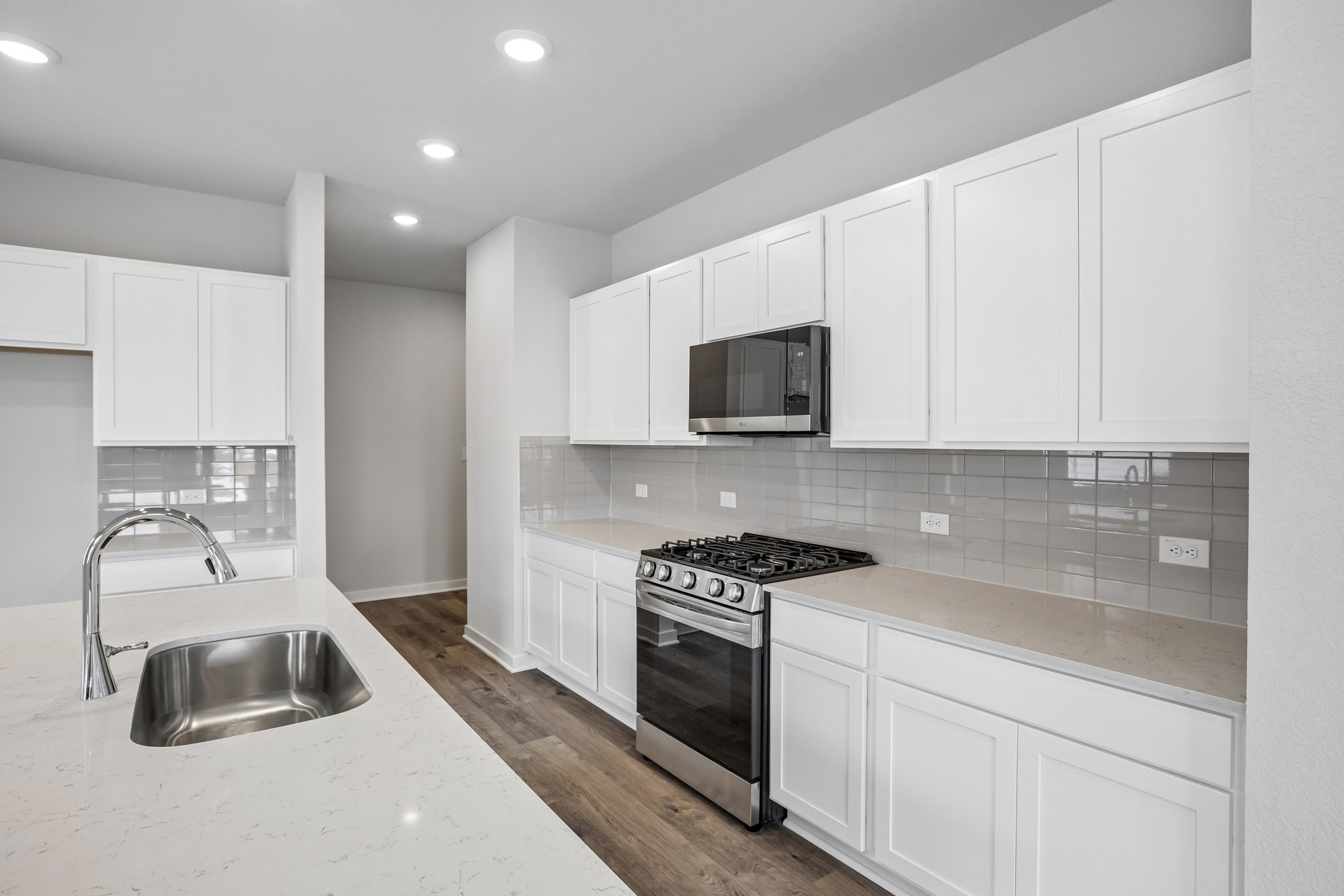 A kitchen with white cabinets.