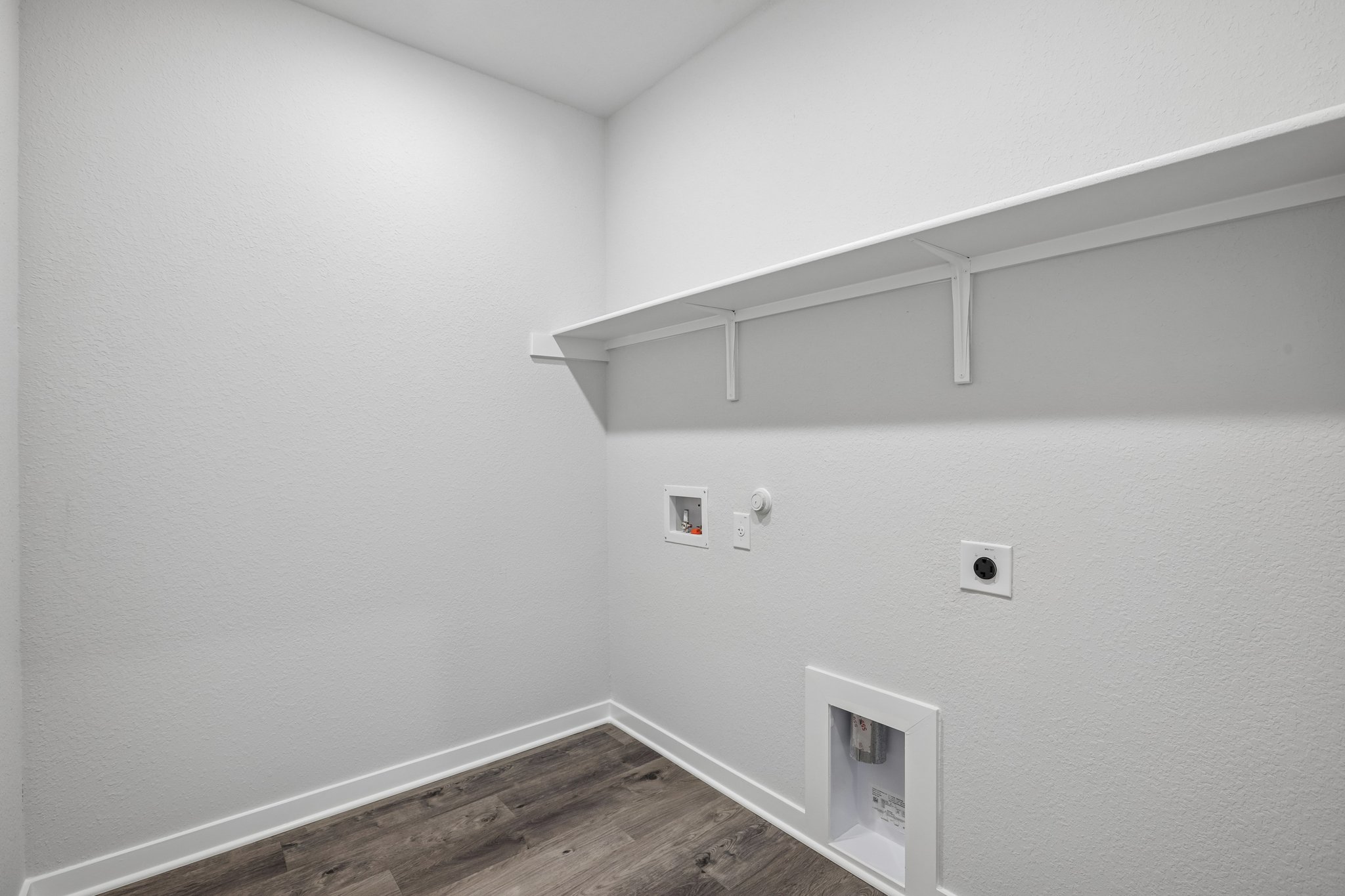 A white room with a wood floor.
