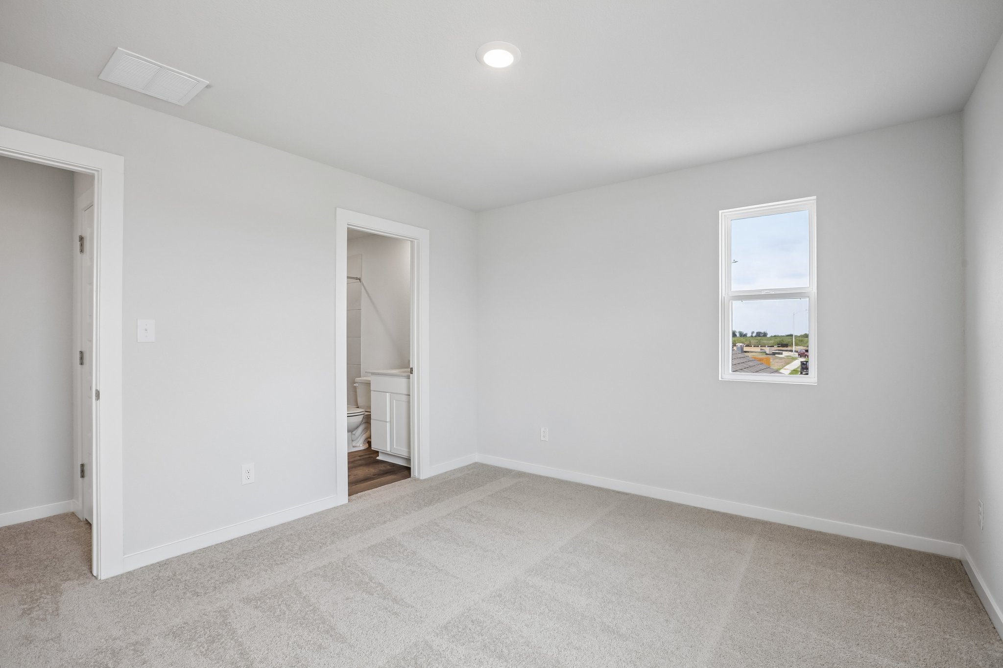 A room with a white carpet and a window.
