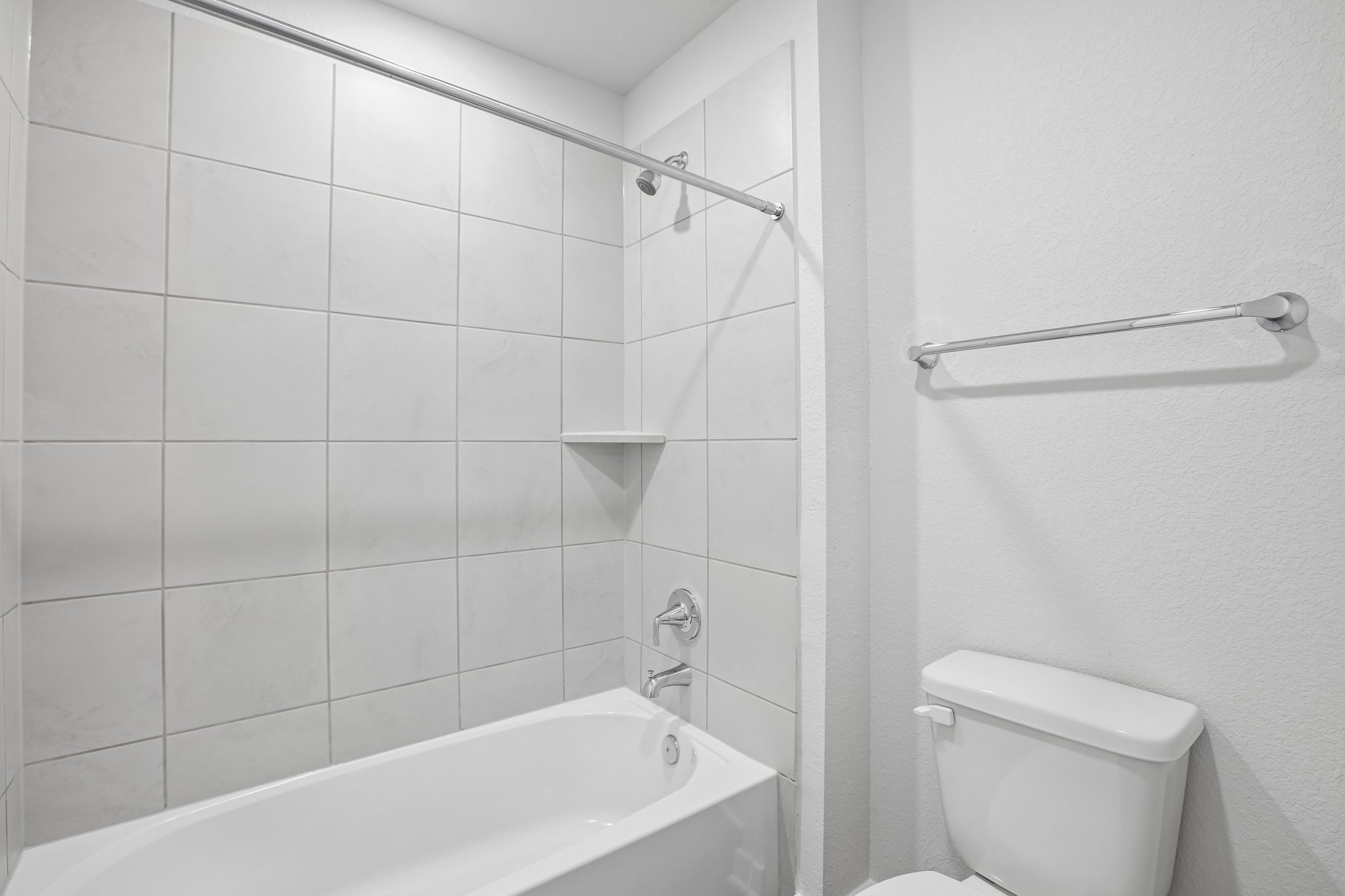 A bathroom with a shower and toilet.
