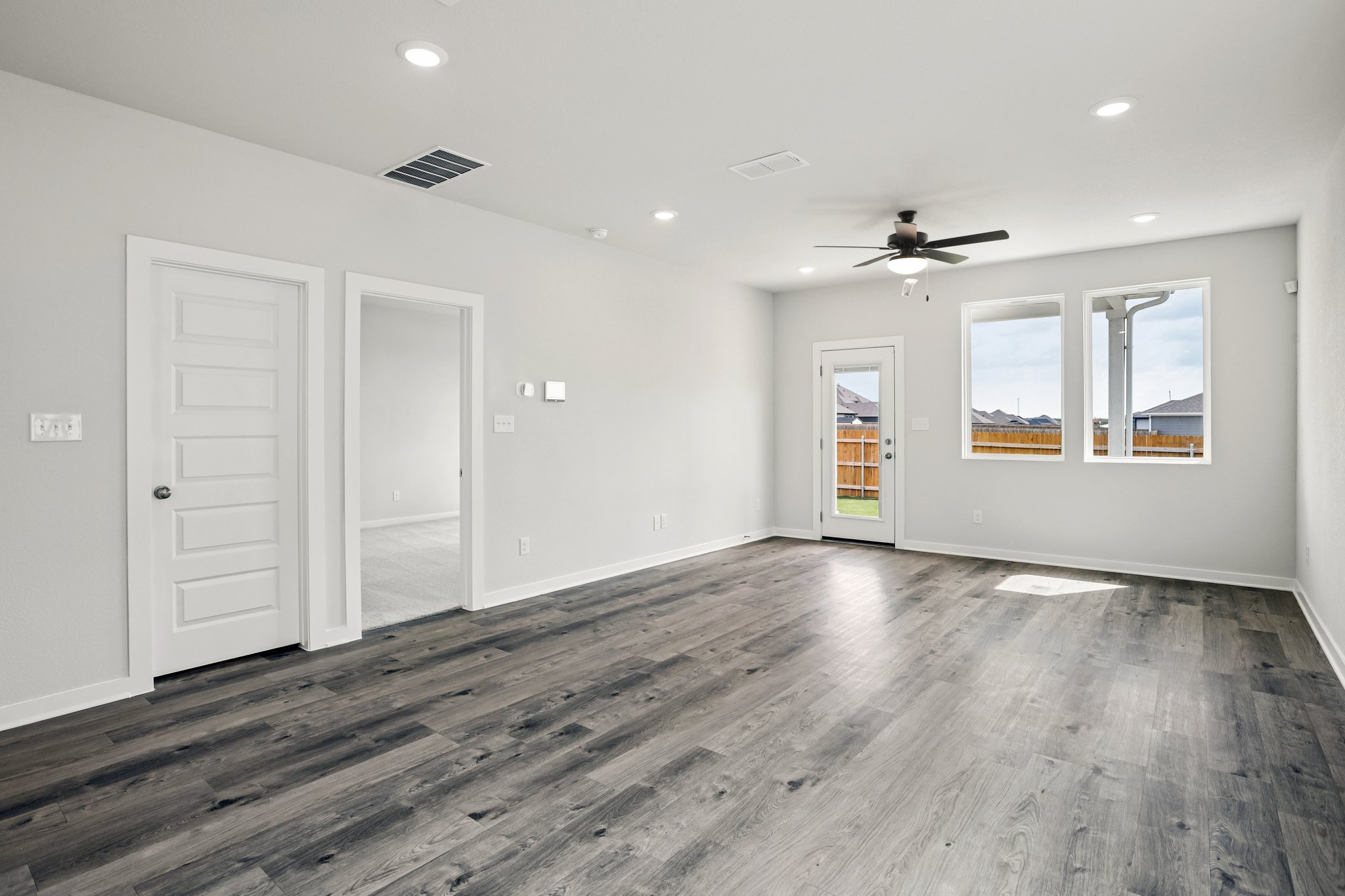 A room with a wood floor and white doors.