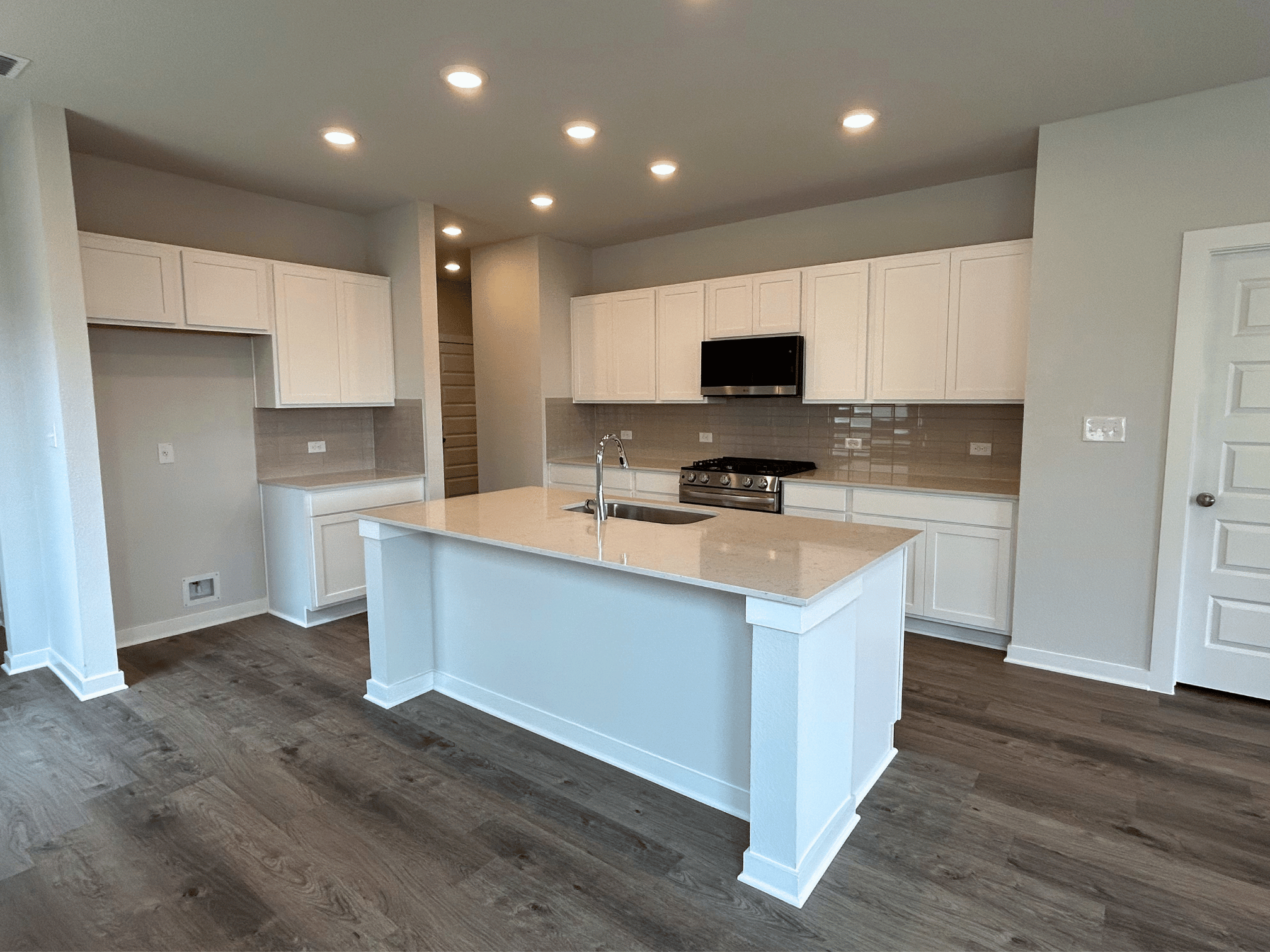 A kitchen with white cabinets.