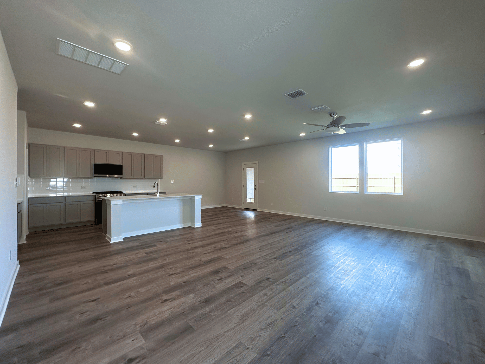 A large empty room with a wood floor and a wood floor.