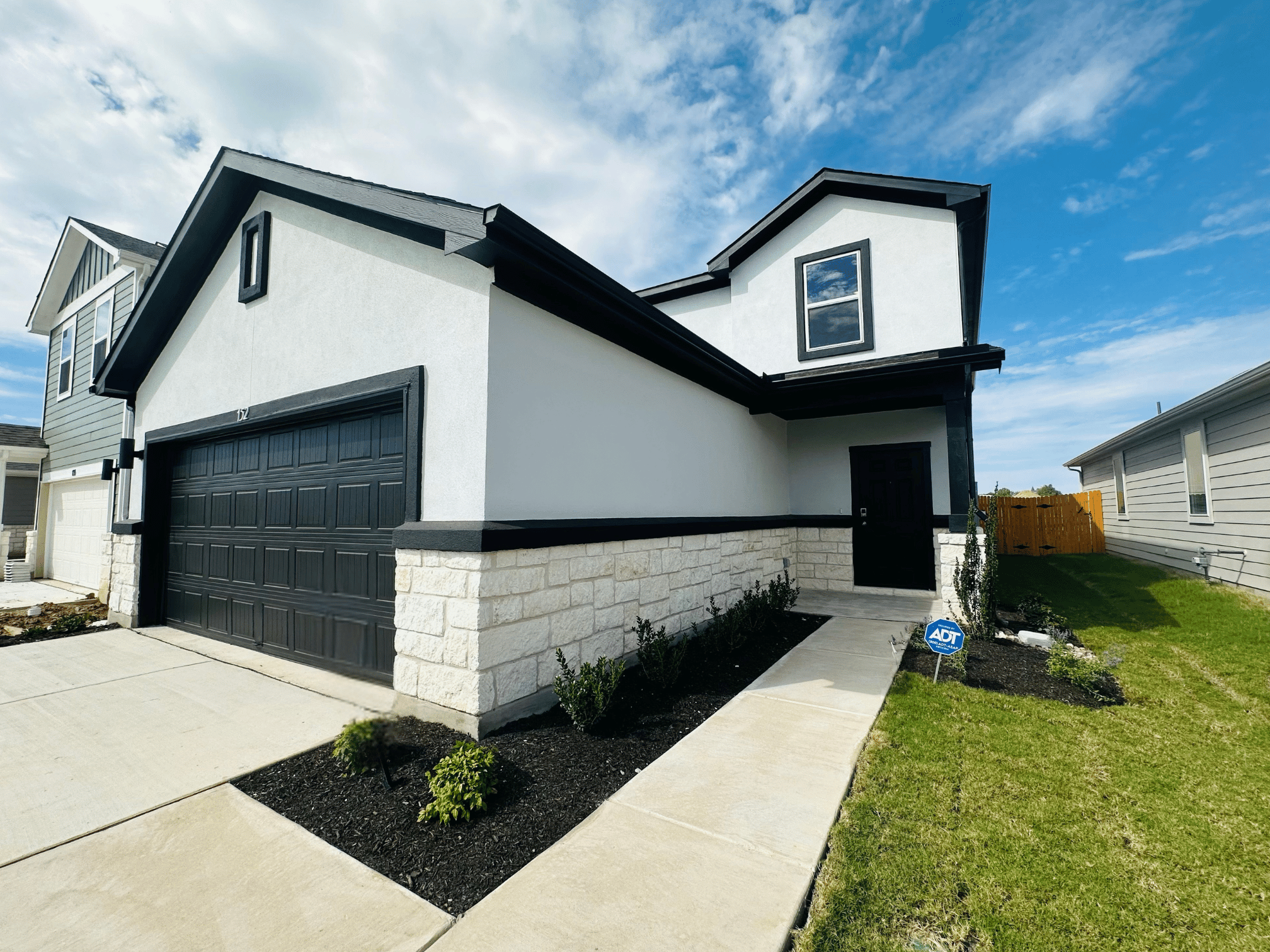 A white house with a black garage.