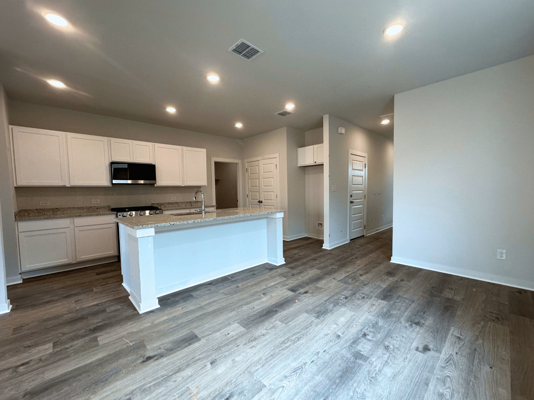 A kitchen with white cabinets.