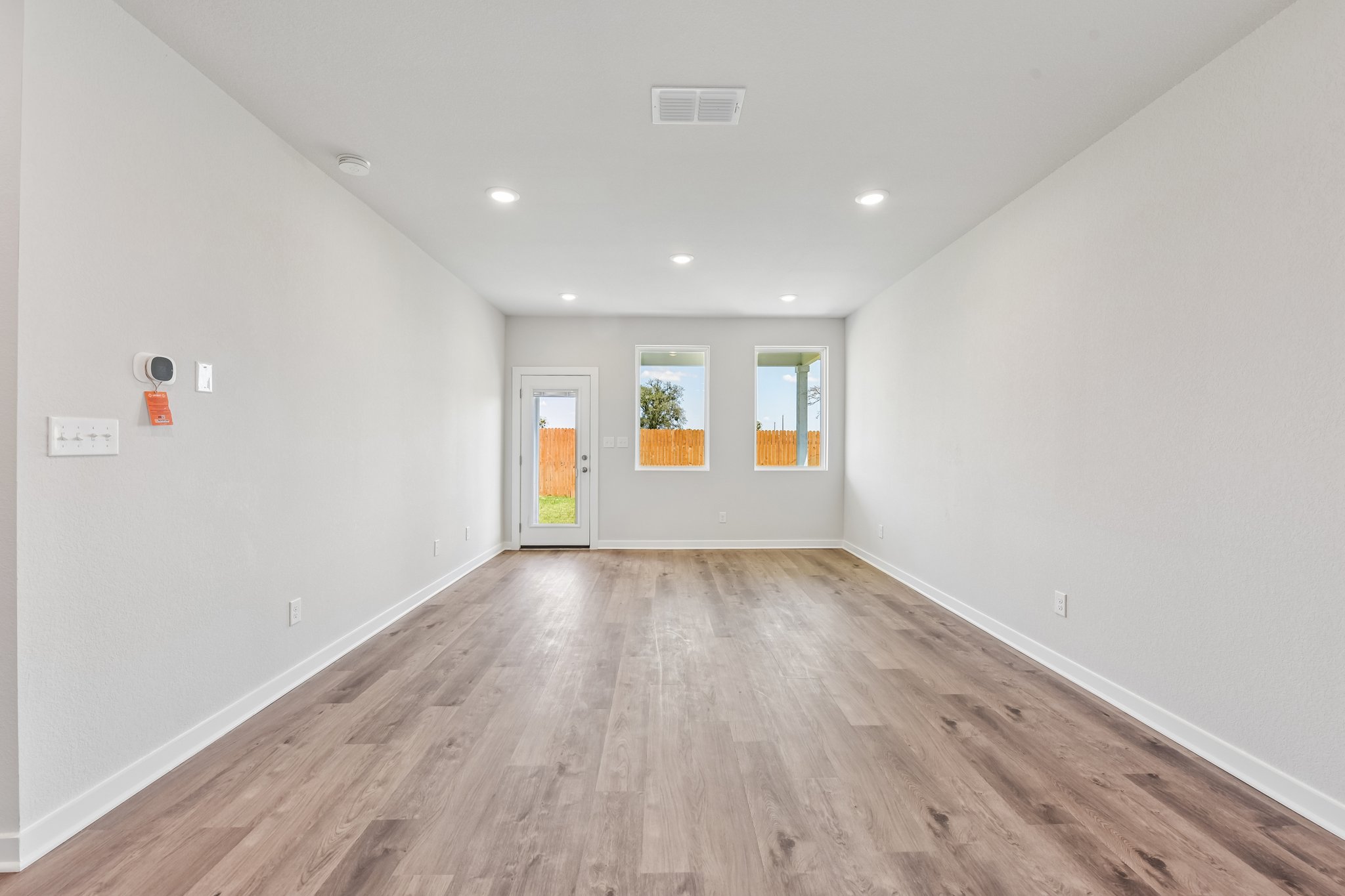 A room with a wood floor and a wood floor with a window.