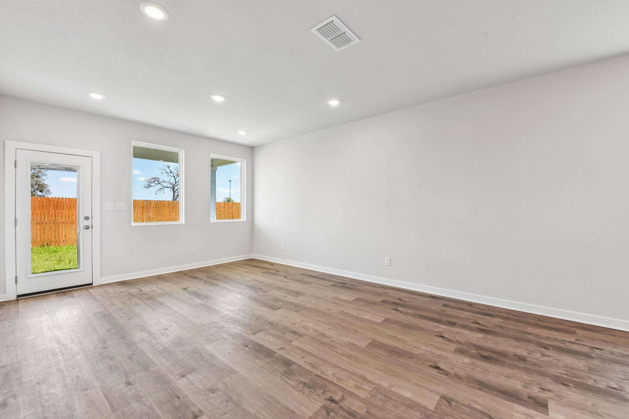 A room with a wood floor and white walls.