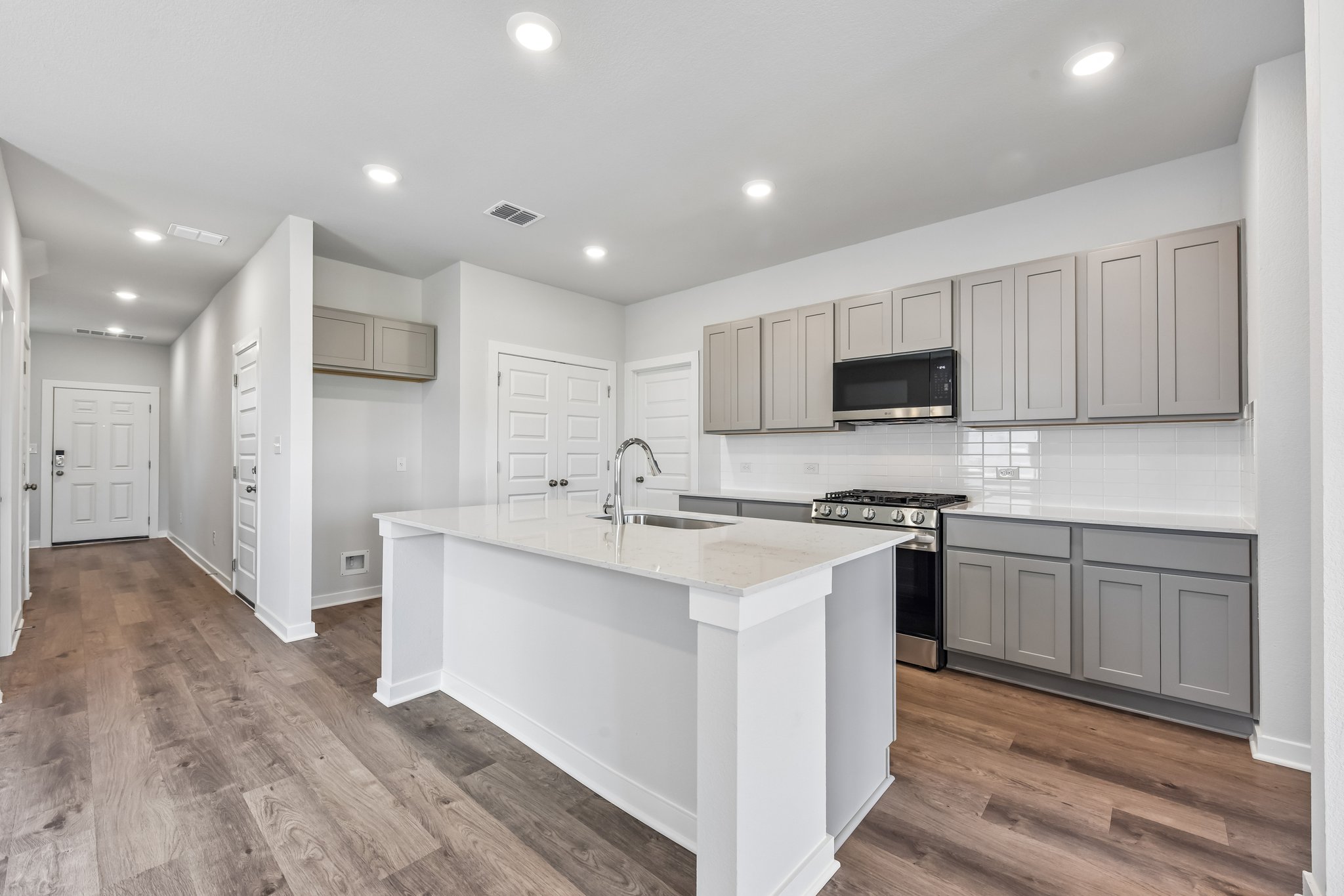 A kitchen with white cabinets.