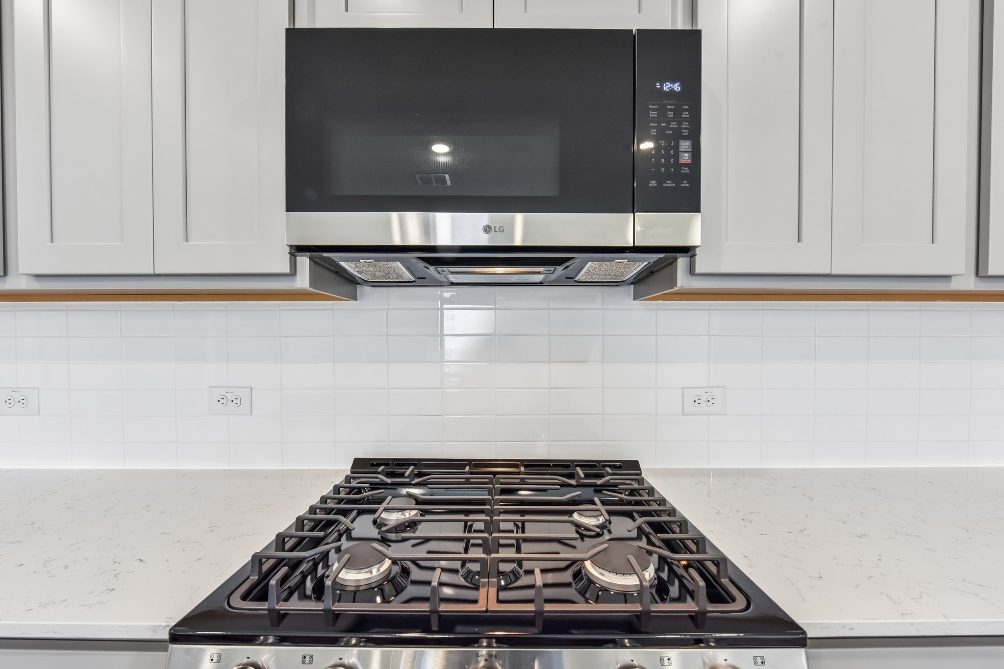 A kitchen with a stove and microwave.