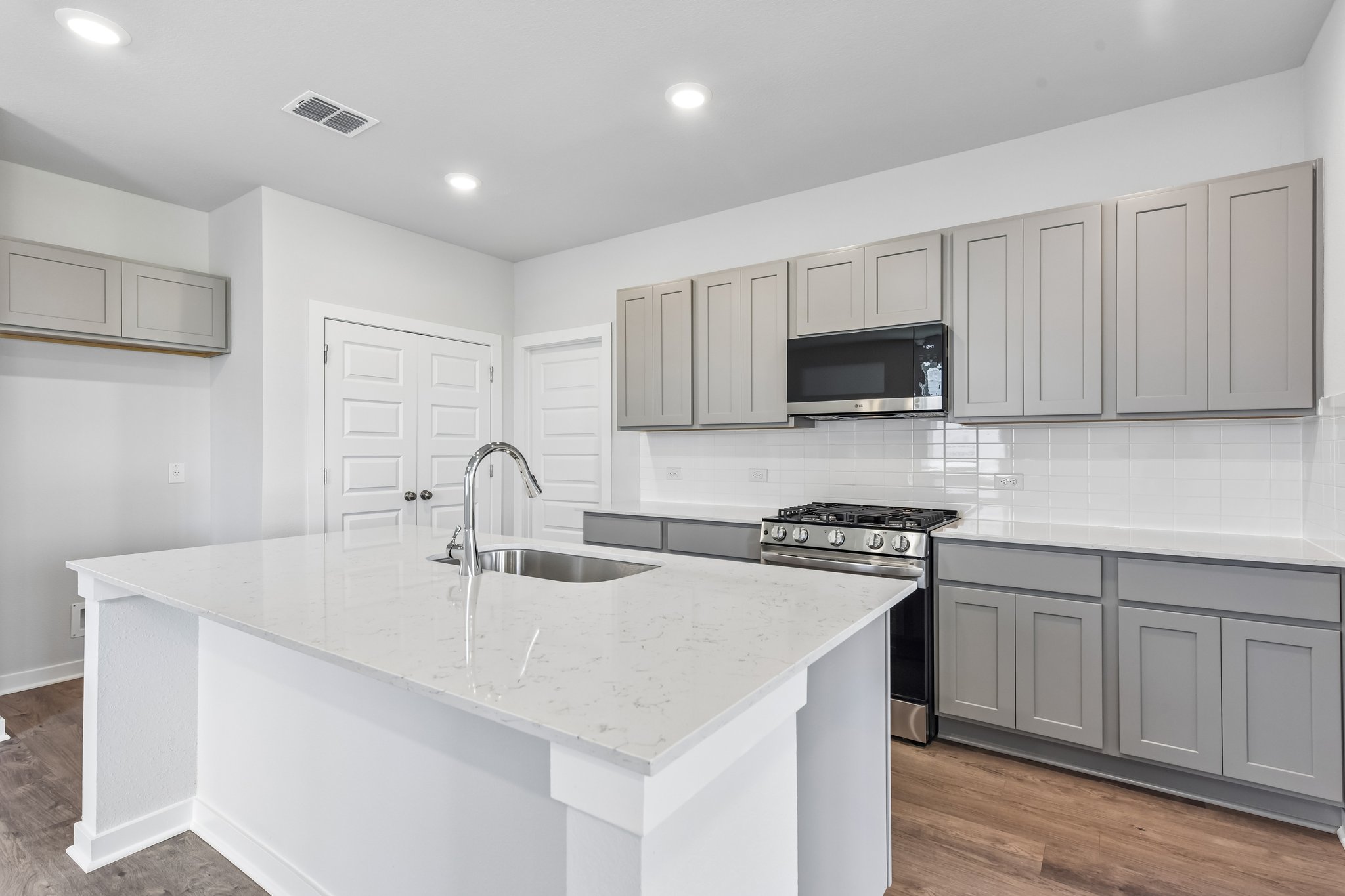 A kitchen with white cabinets.