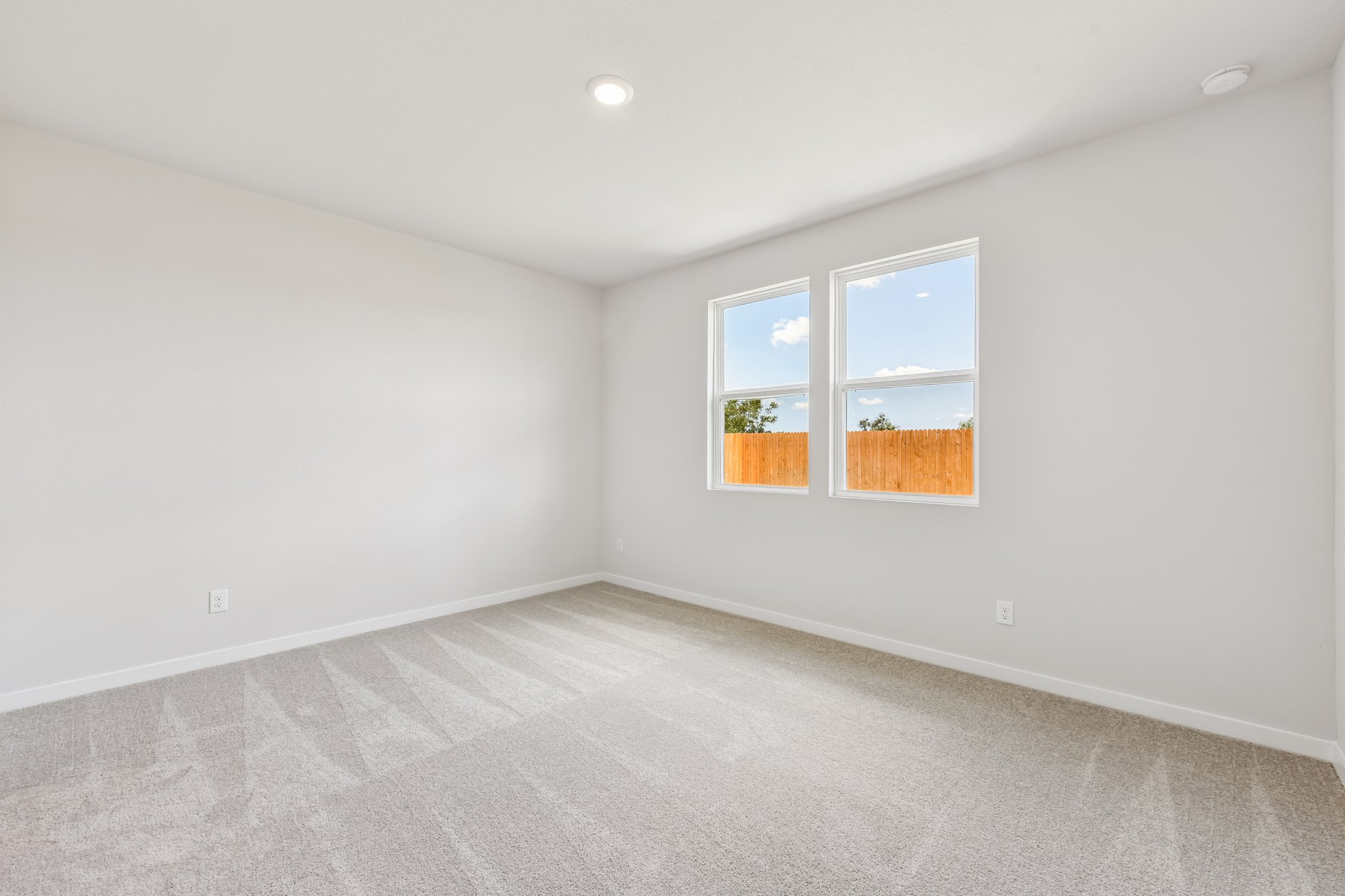 A room with a window and a carpet.
