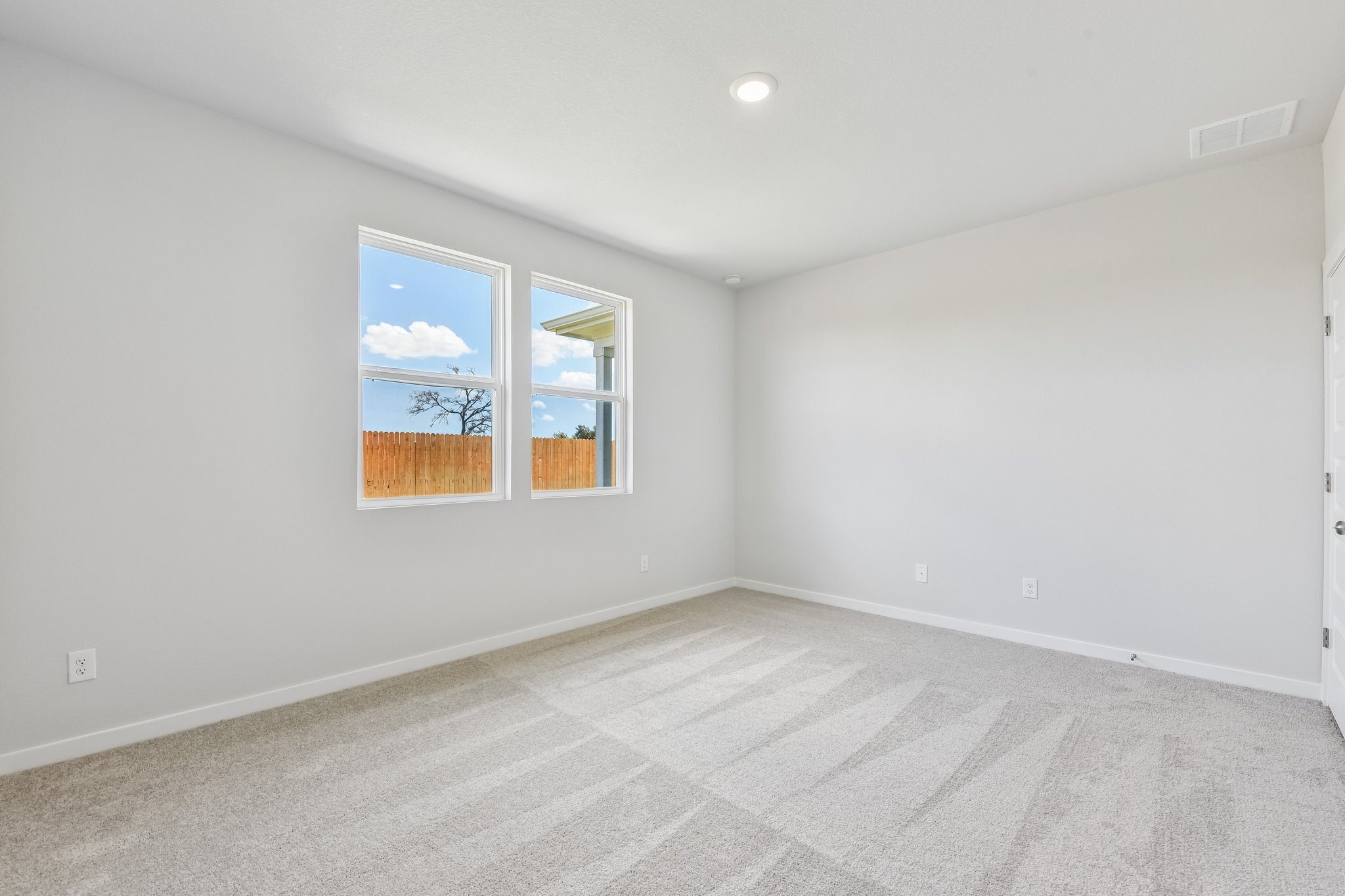 A room with a window and a rug.