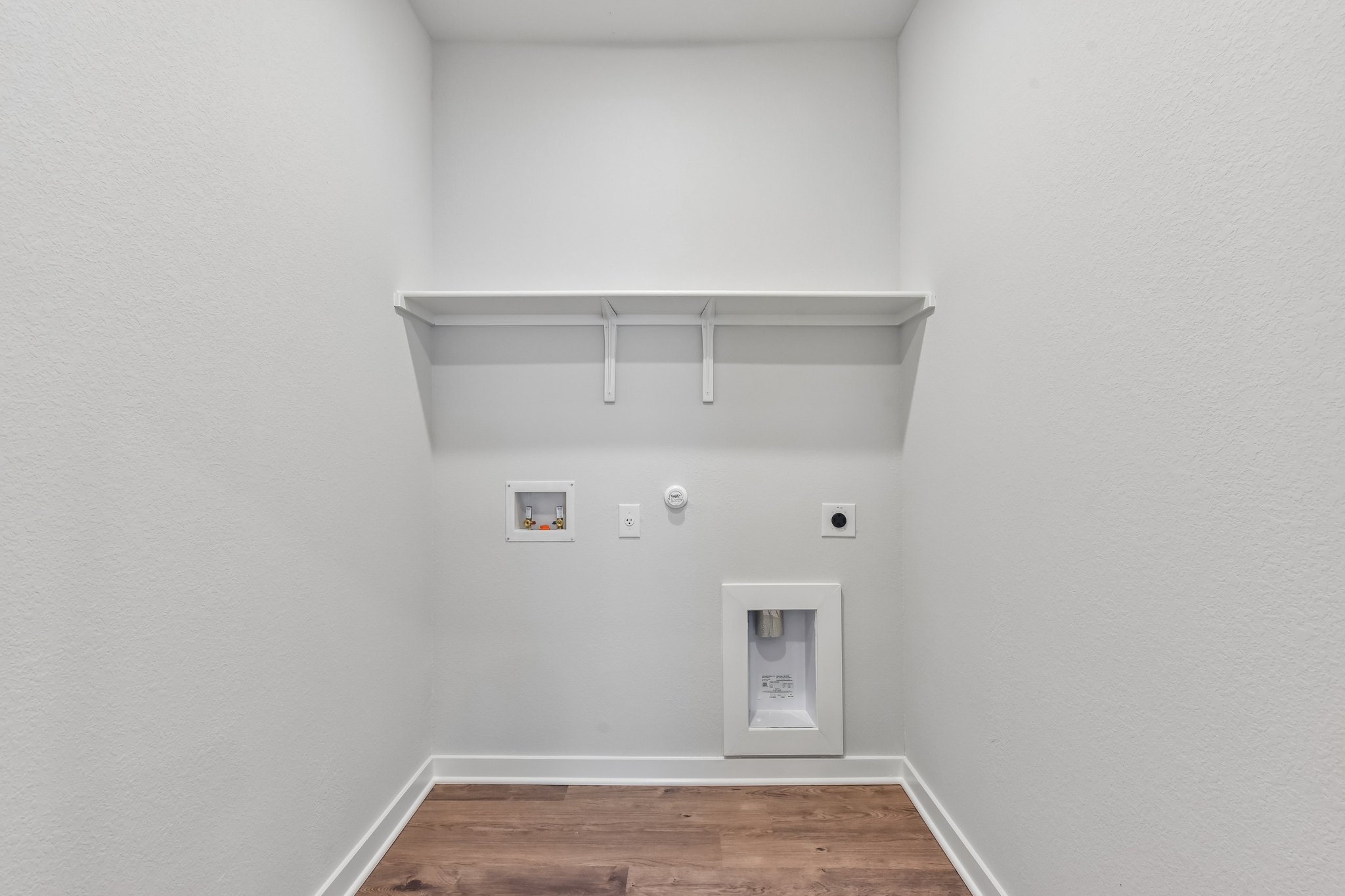 A white wall with a light switch.