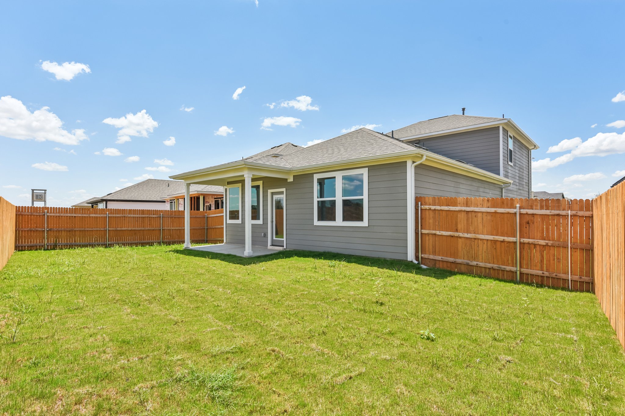 A house with a fence and grass.
